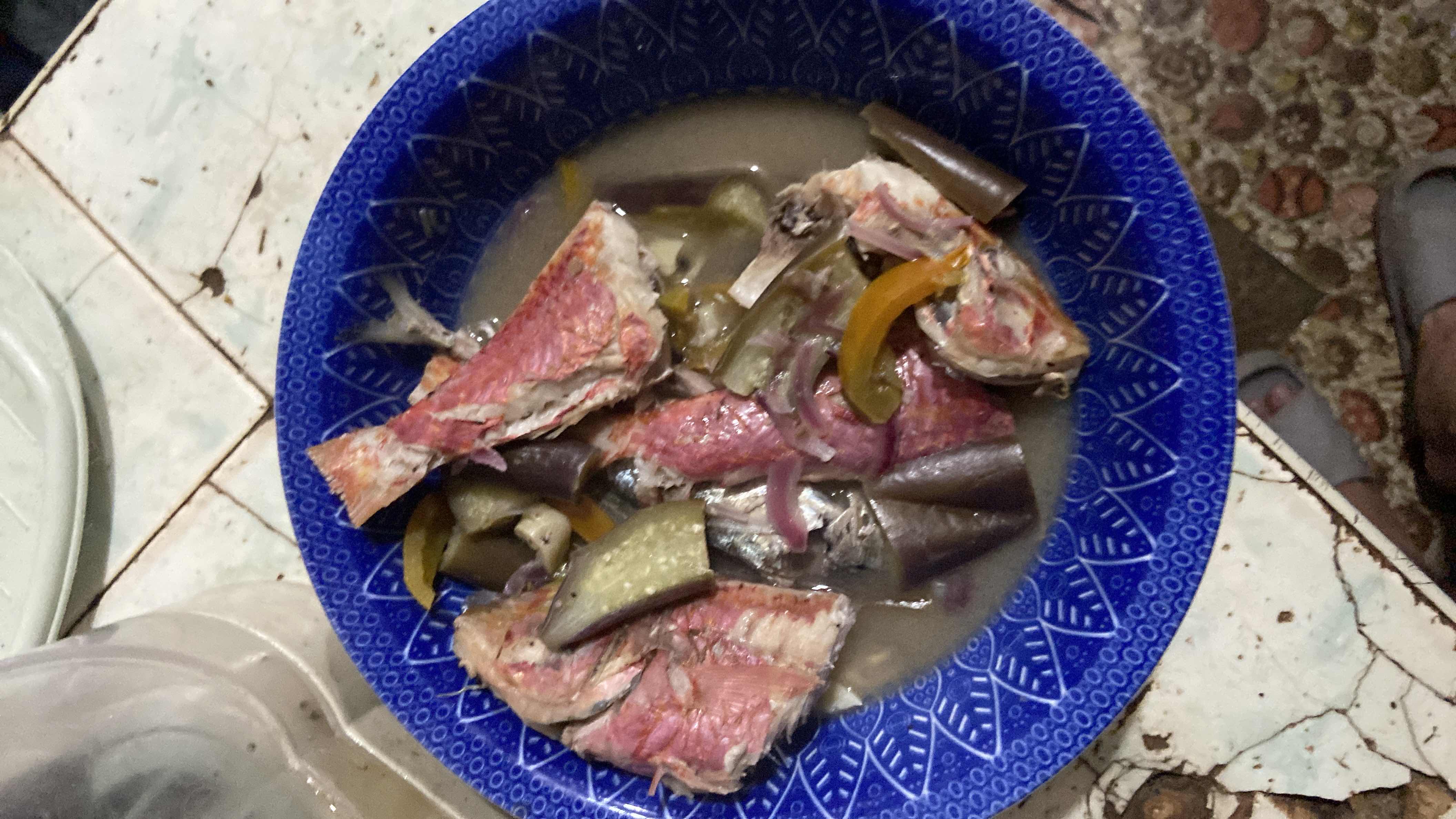 A dish consisting of fish, eggplant, and bell peppers in a light broth, providing a balanced mix of protein, carbs, and fats.