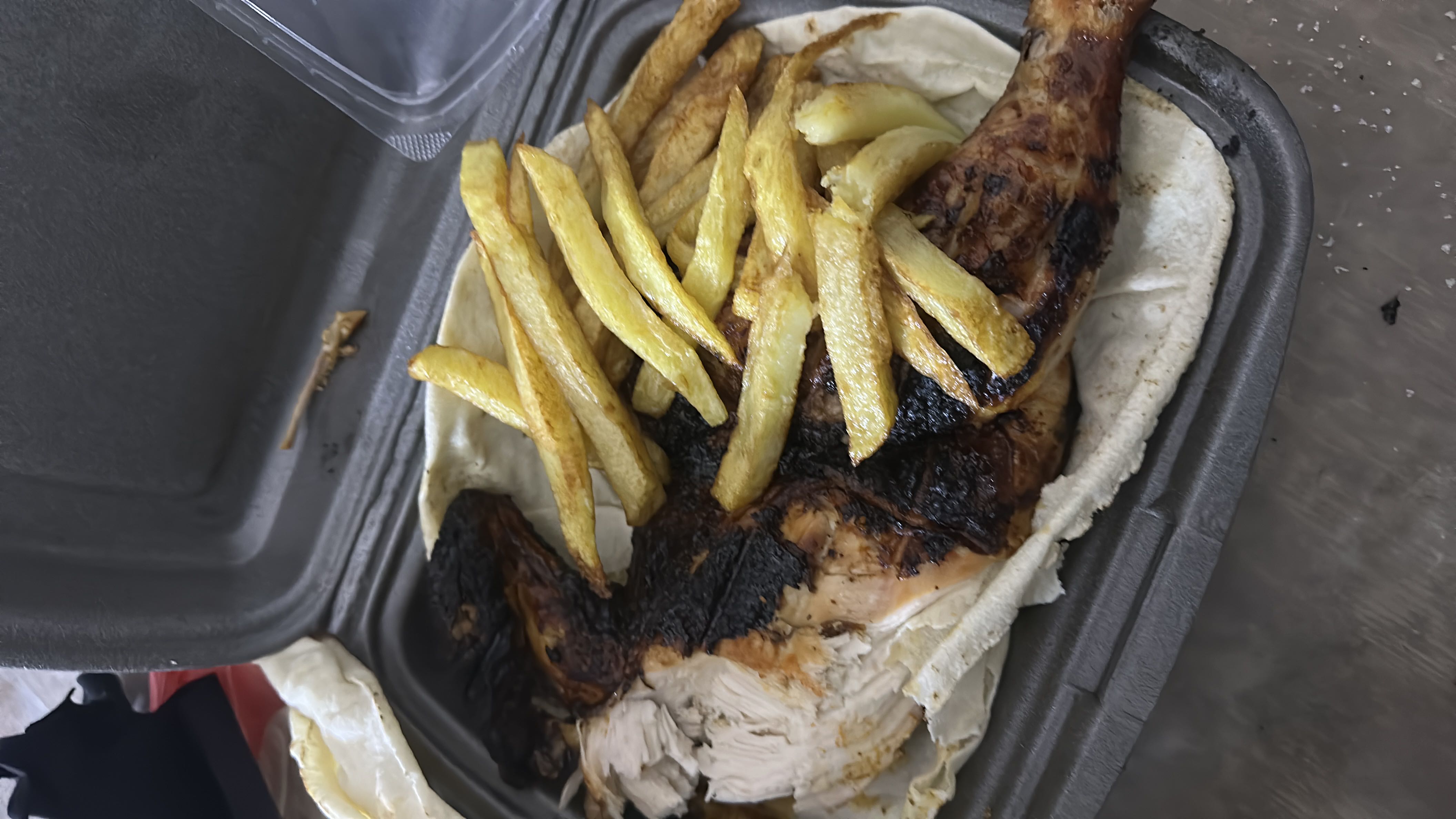 A meal consisting of grilled chicken, french fries, and flatbread, providing a balanced mix of protein, carbs, and fats.