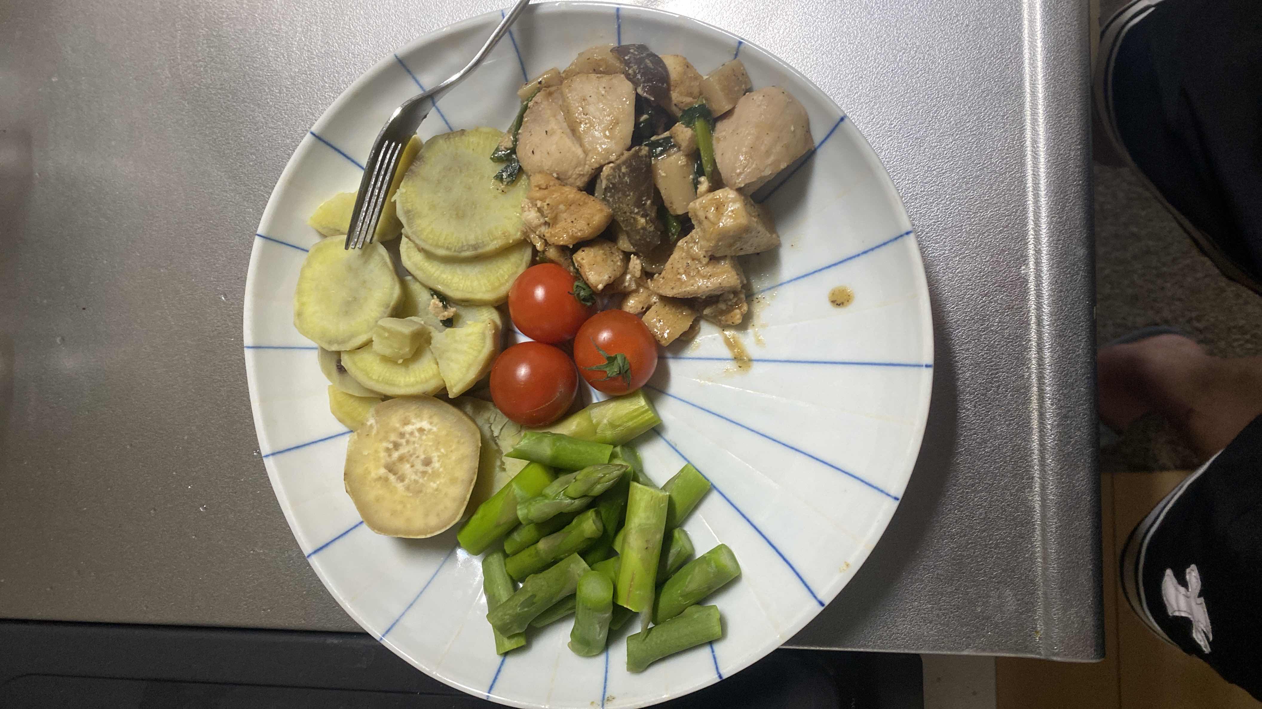 A balanced meal consisting of chicken, sweet potato, asparagus, cherry tomatoes, and eggplant, providing a good mix of protein, carbs, and fats.