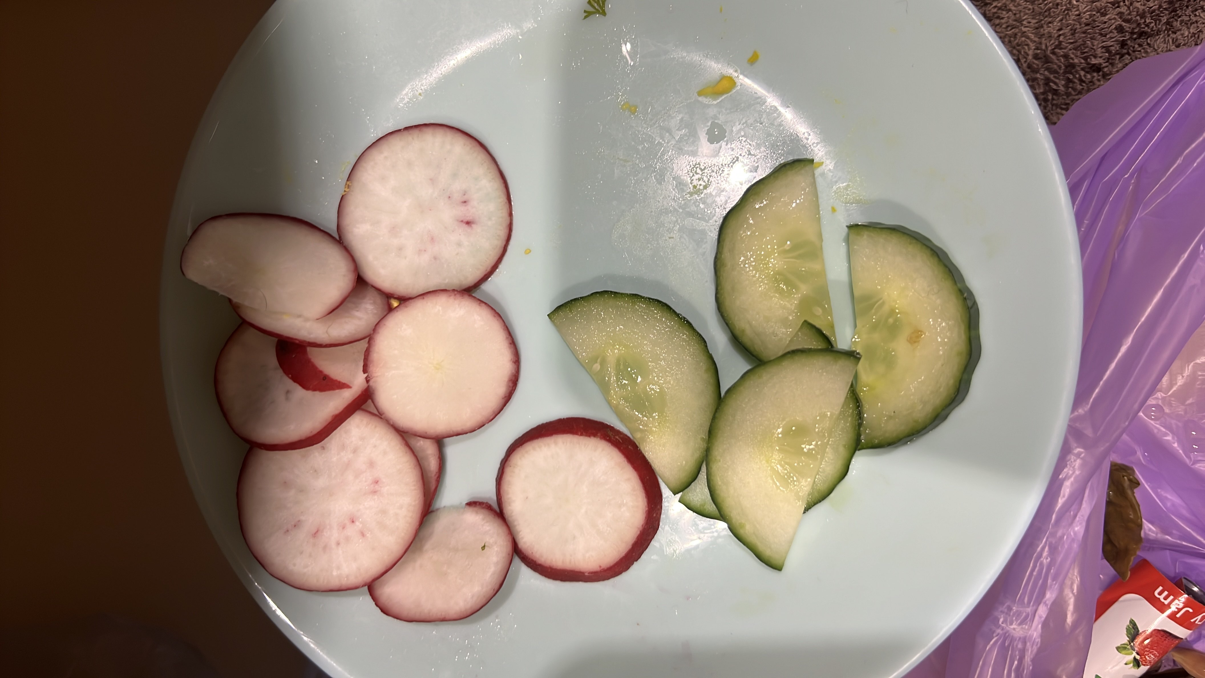 The image shows a plate with sliced radishes and cucumbers, which are low-calorie vegetables rich in nutrients.