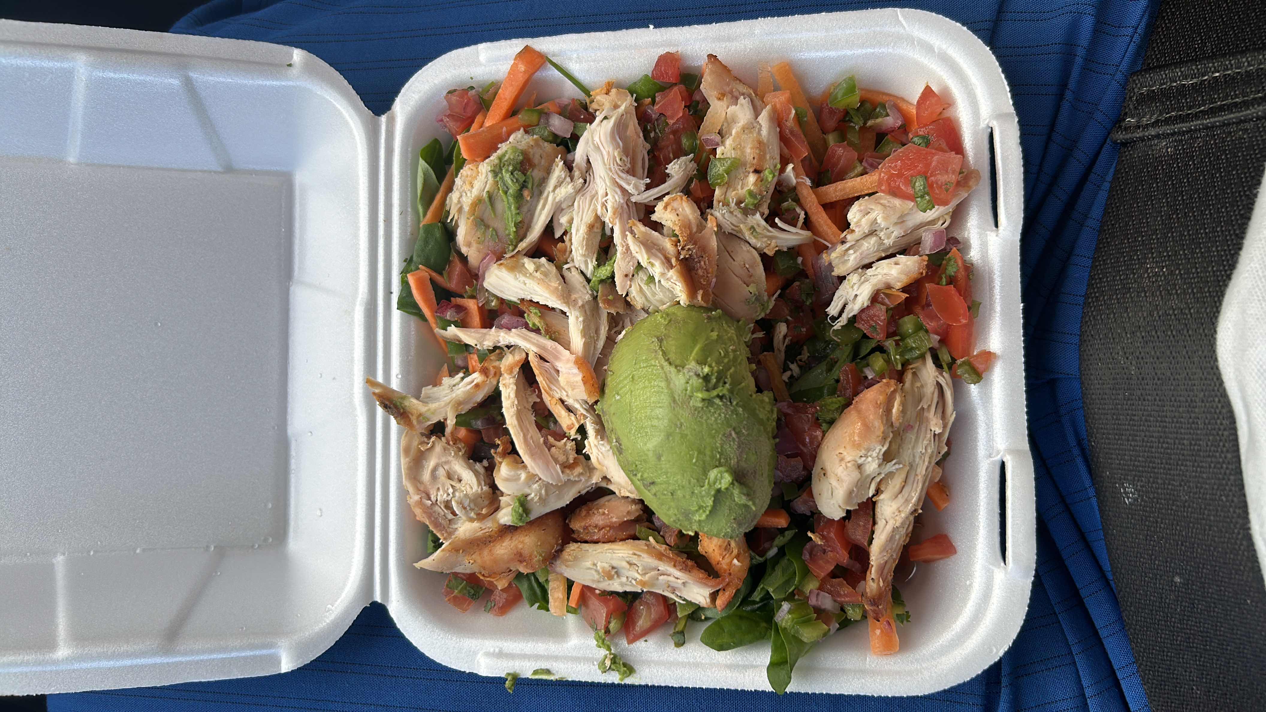 A healthy salad with shredded chicken, avocado, spinach, tomatoes, and carrots, providing a balanced mix of protein, fats, and carbs.