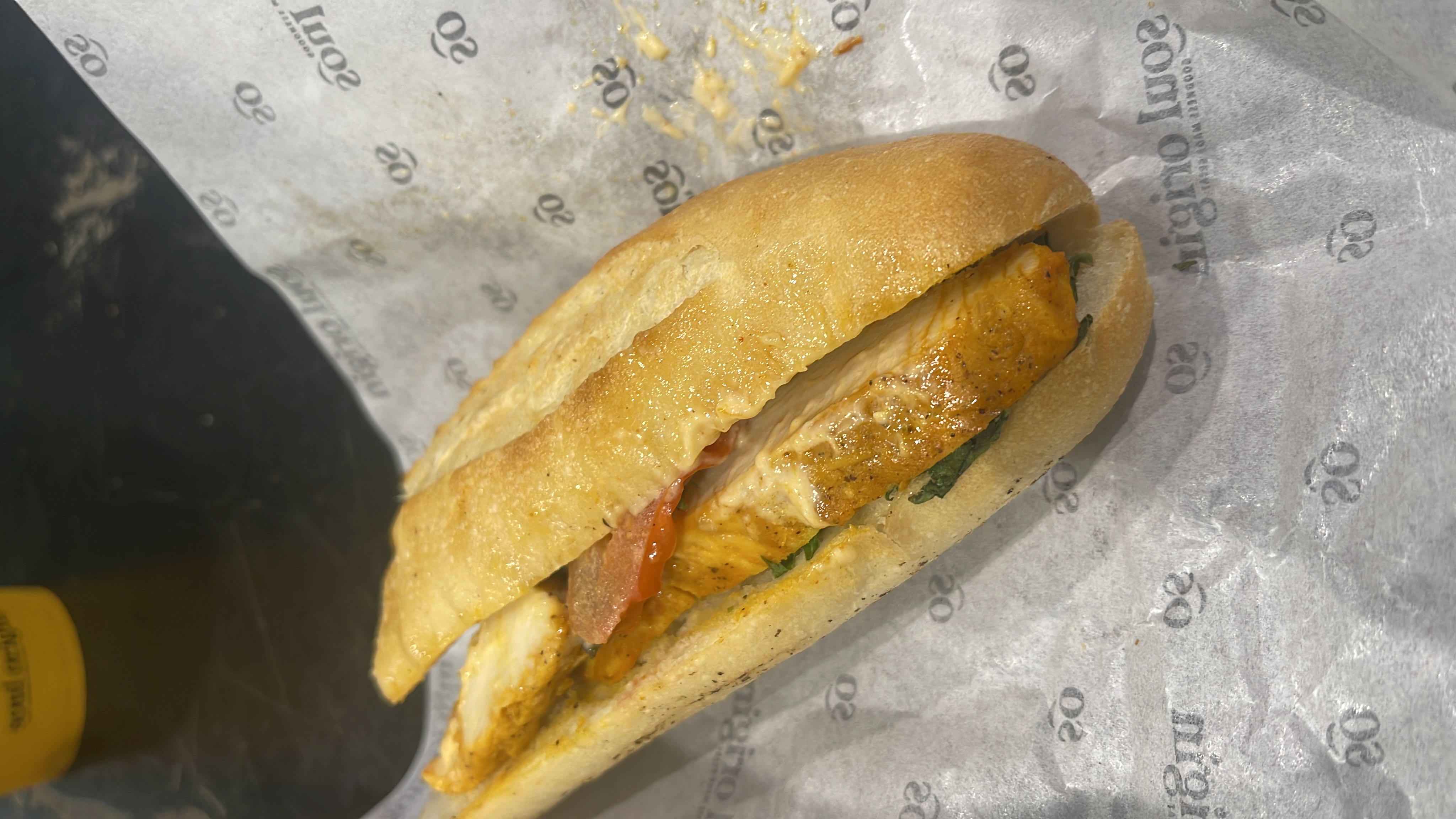 A chicken sandwich with bread, tomato, and spinach, offering a balanced mix of protein, carbs, and fats.