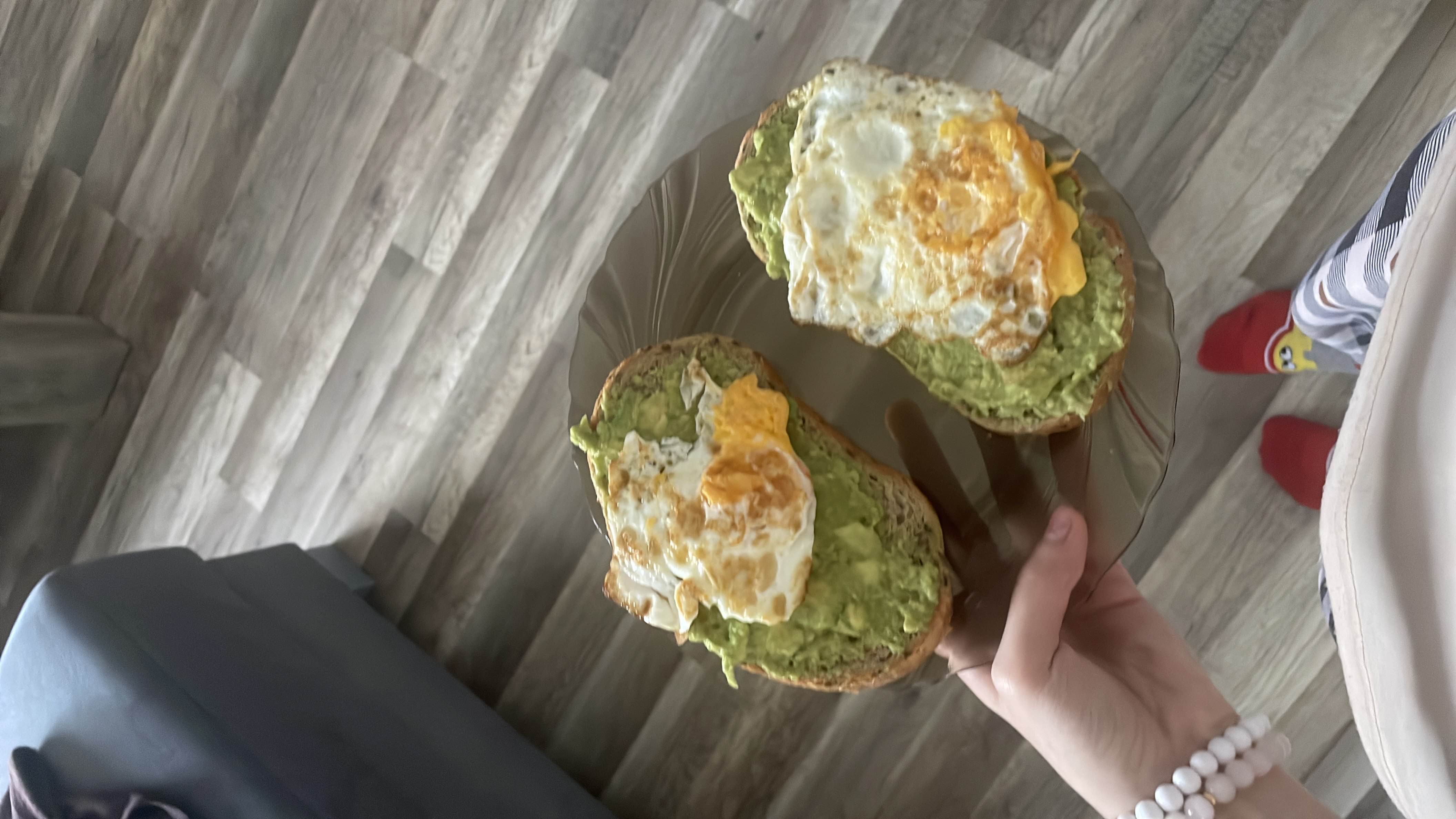 This is a plate of avocado toast topped with fried eggs, providing a balanced mix of healthy fats, protein, and carbohydrates.