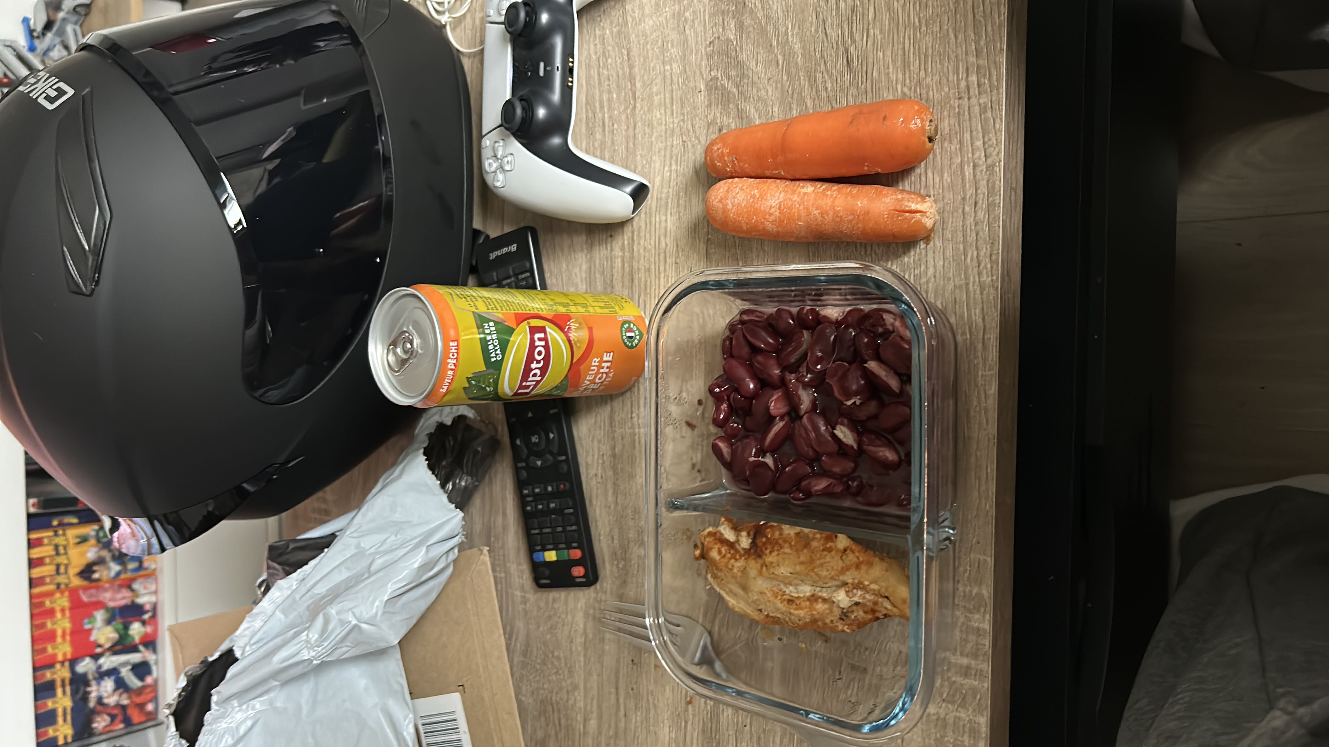 A balanced meal consisting of grilled chicken breast, kidney beans, carrots, and a can of peach iced tea.