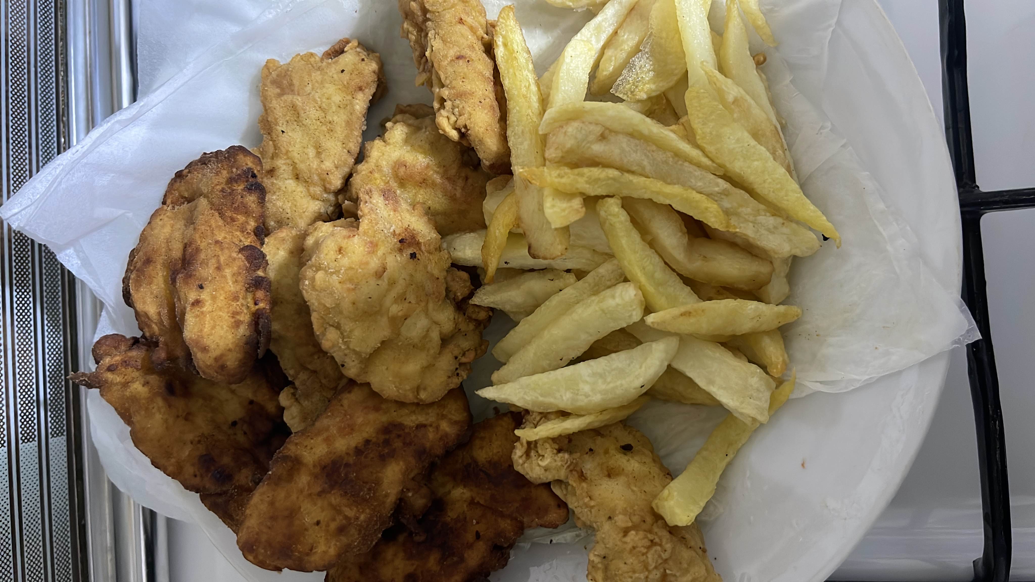 A plate of fried chicken and french fries, high in calories and fats, with moderate protein content.