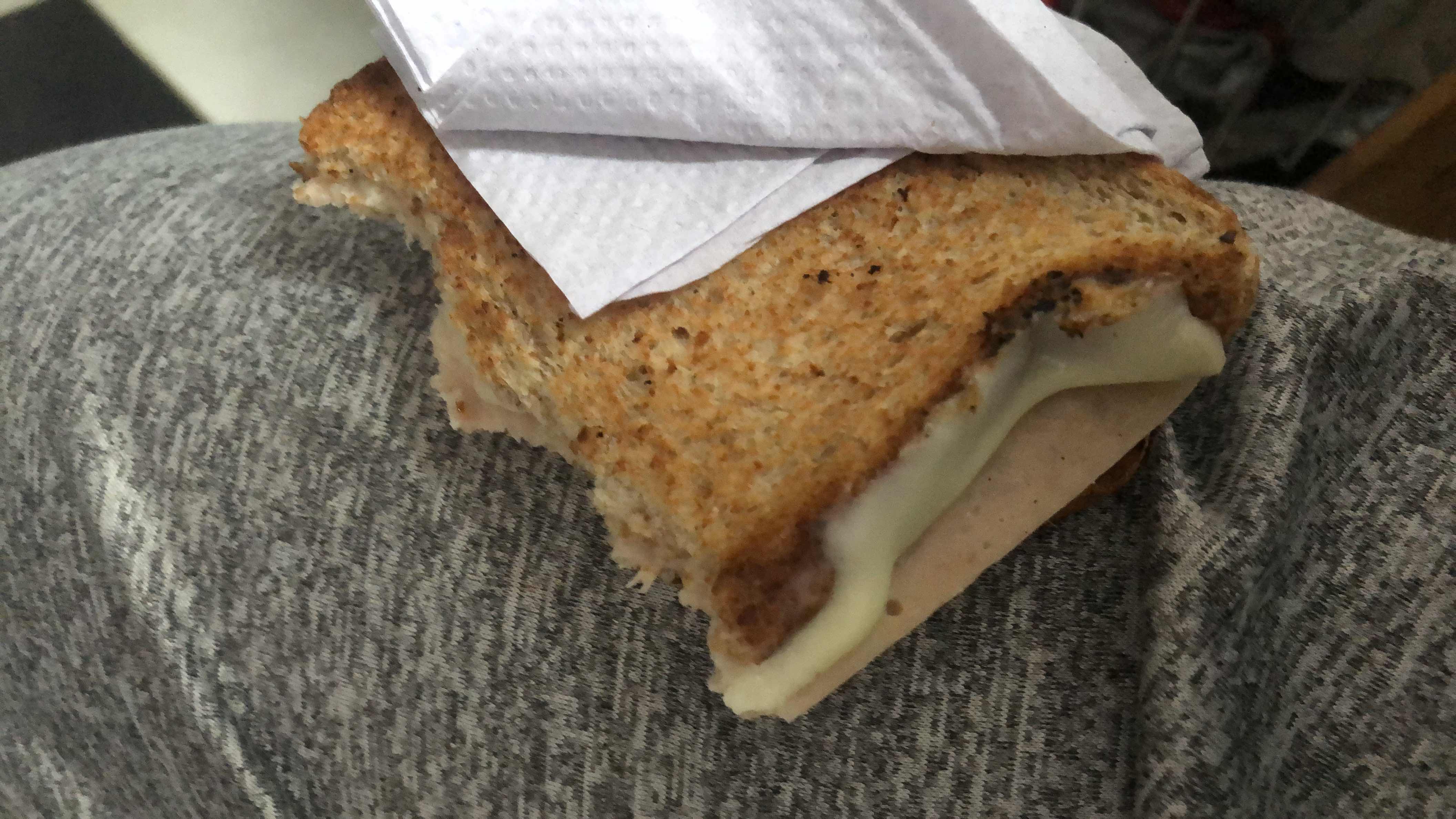 A toasted sandwich made with whole grain bread, cheese, and turkey slices, providing a balanced mix of protein, carbs, and fats.