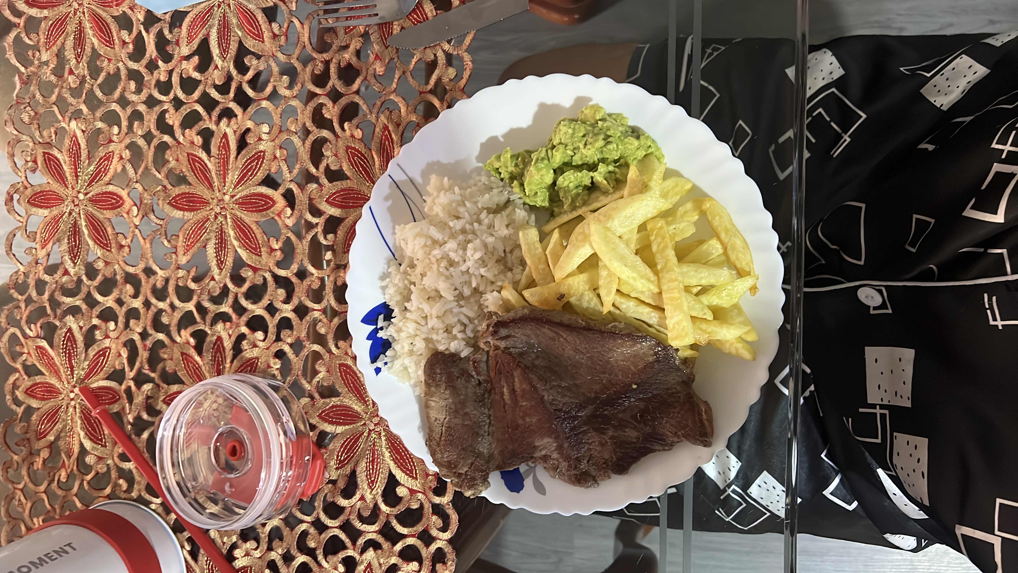 A balanced meal consisting of beef steak, white rice, french fries, and guacamole.
