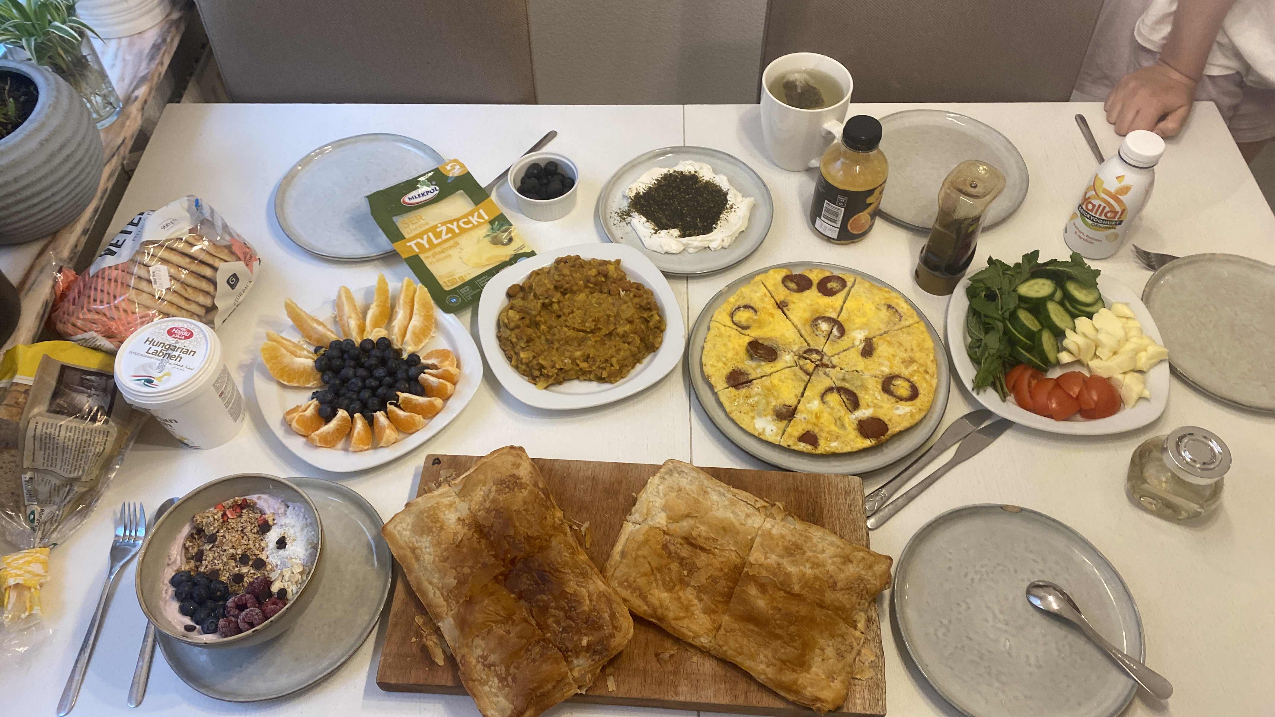 A balanced meal featuring fruits, vegetables, dairy, and baked goods, providing a mix of proteins, carbs, and fats.