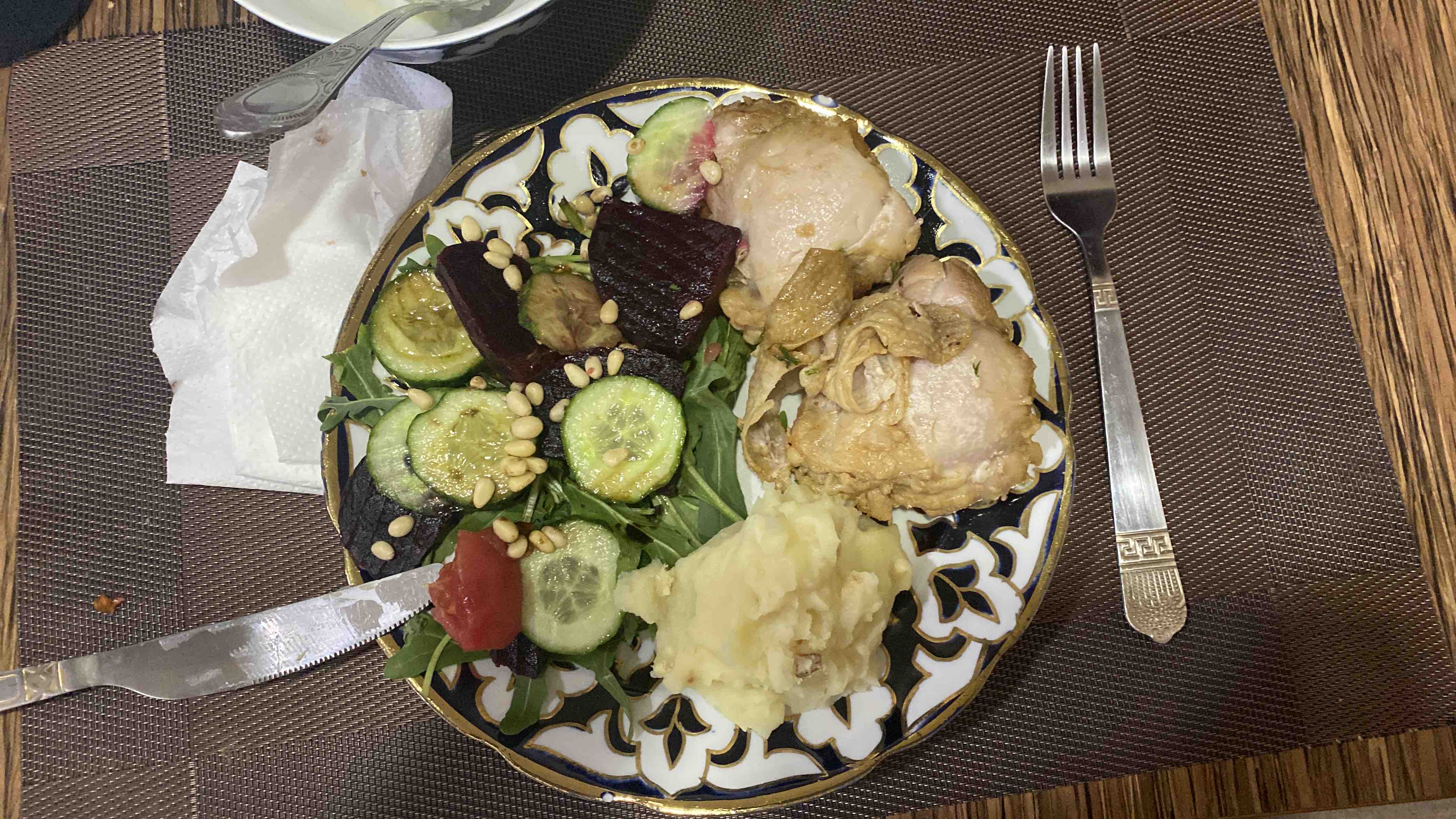 A balanced meal consisting of chicken, mashed potatoes, and a fresh salad with cucumber, beetroot, arugula, and pine nuts.