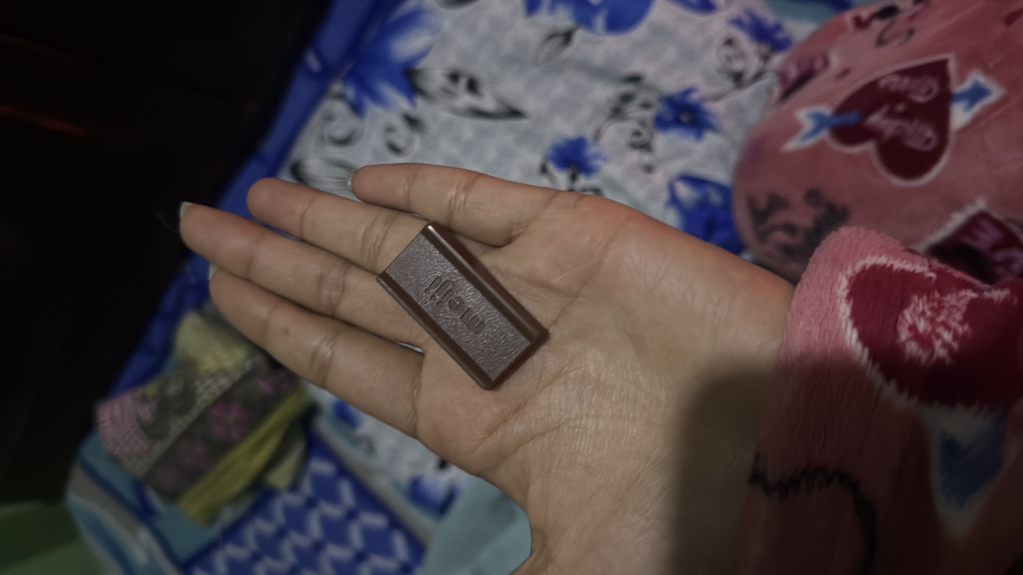 A small piece of Meiji chocolate, likely containing moderate calories, low protein, and a mix of carbs and fats.
