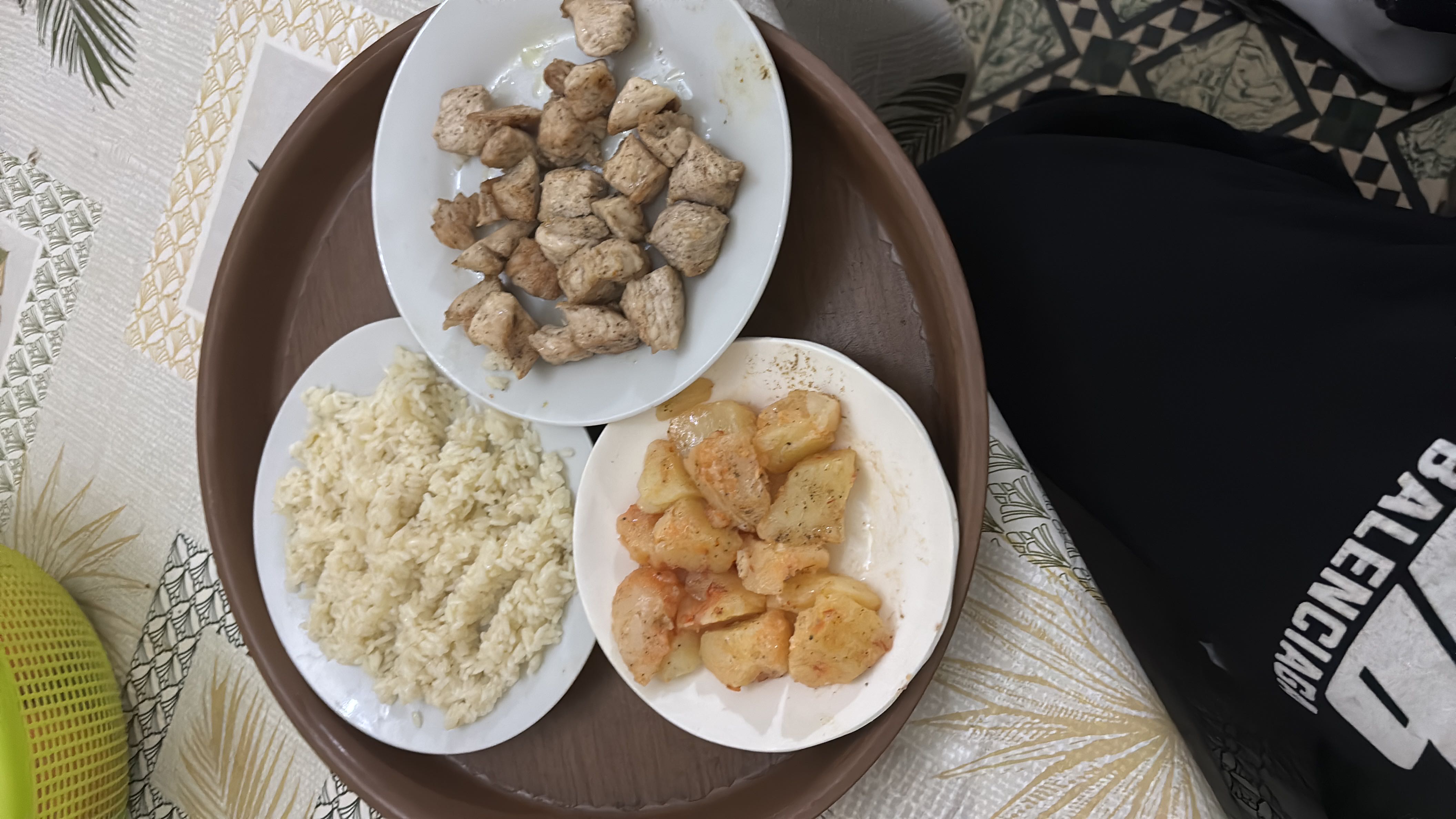 A balanced meal consisting of rice, grilled chicken, and seasoned potatoes, providing a good mix of protein, carbohydrates, and fats.