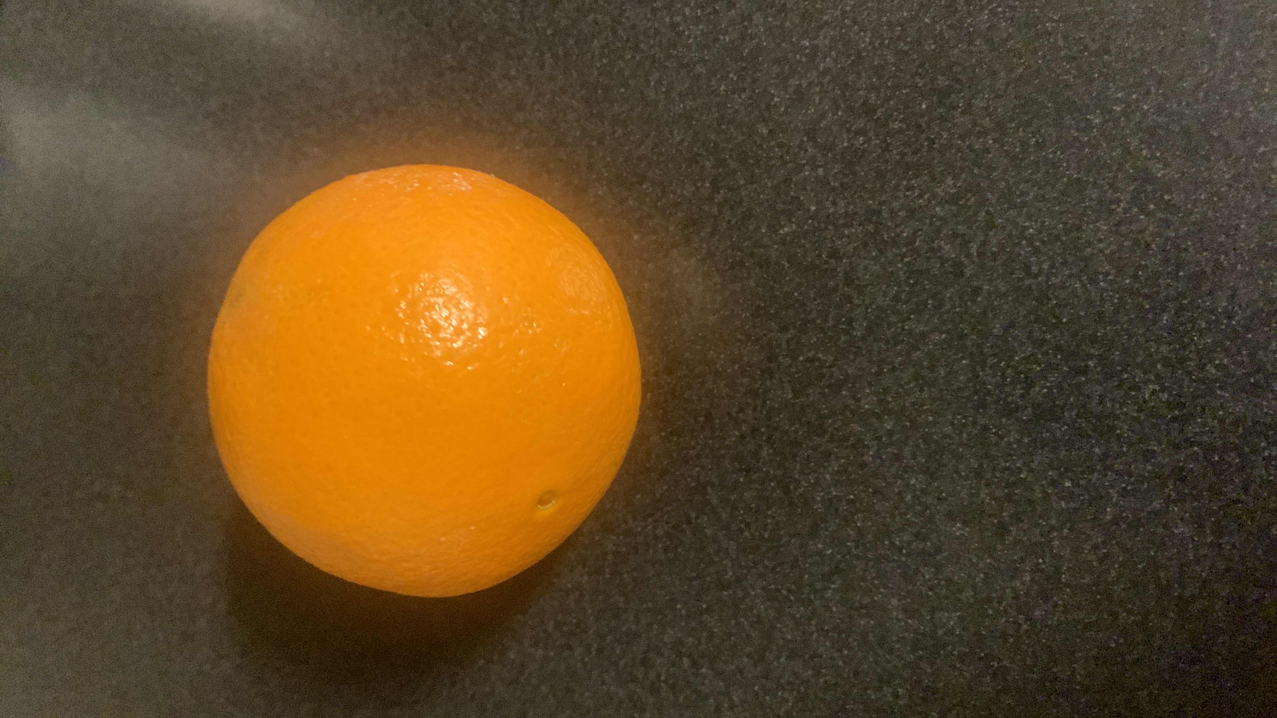 The image shows an orange, a citrus fruit rich in vitamin C, with low calories and high nutritional value.