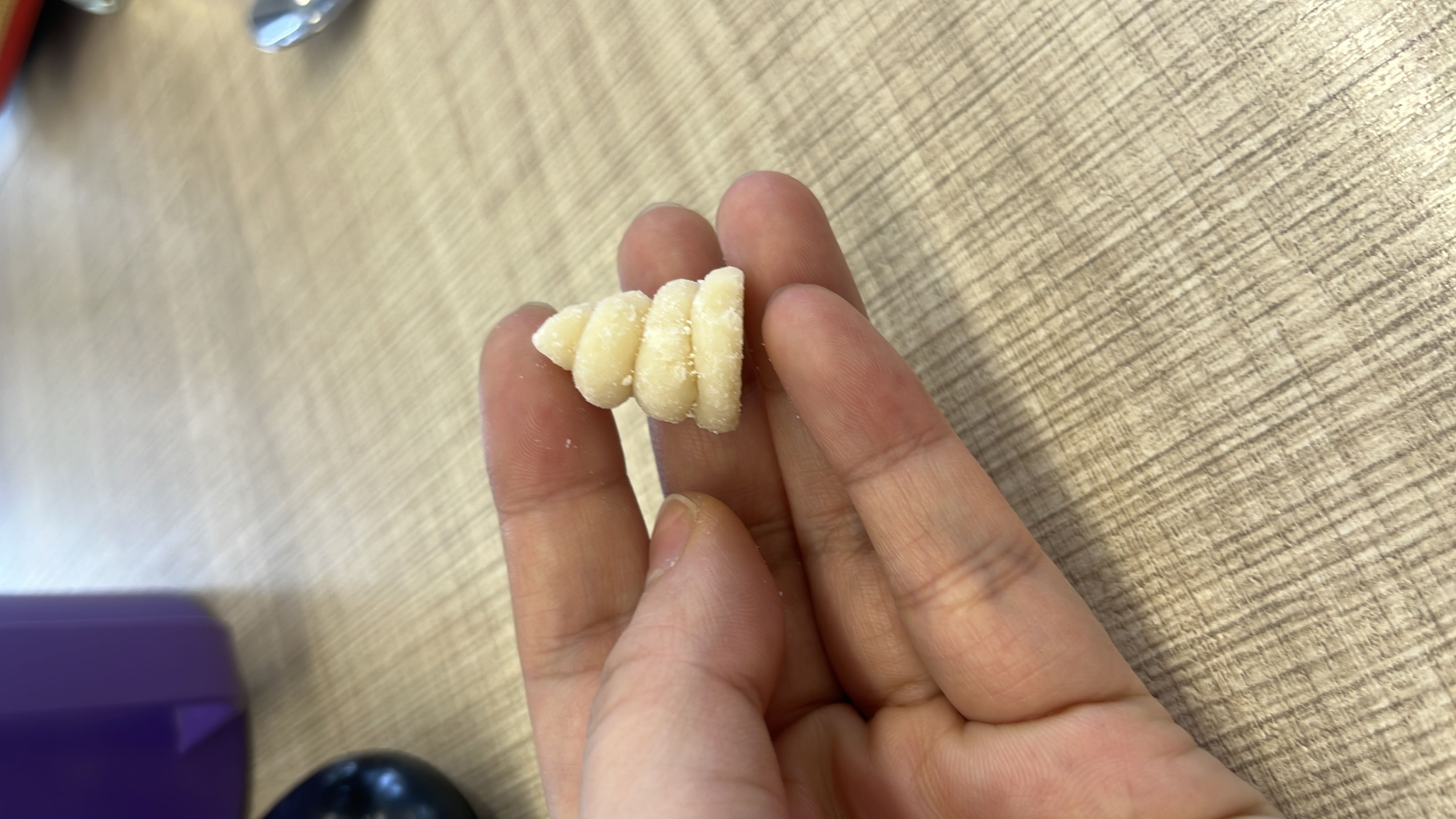 A small, spiral-shaped butter cookie with a light dusting of sugar, likely containing butter, sugar, and flour.