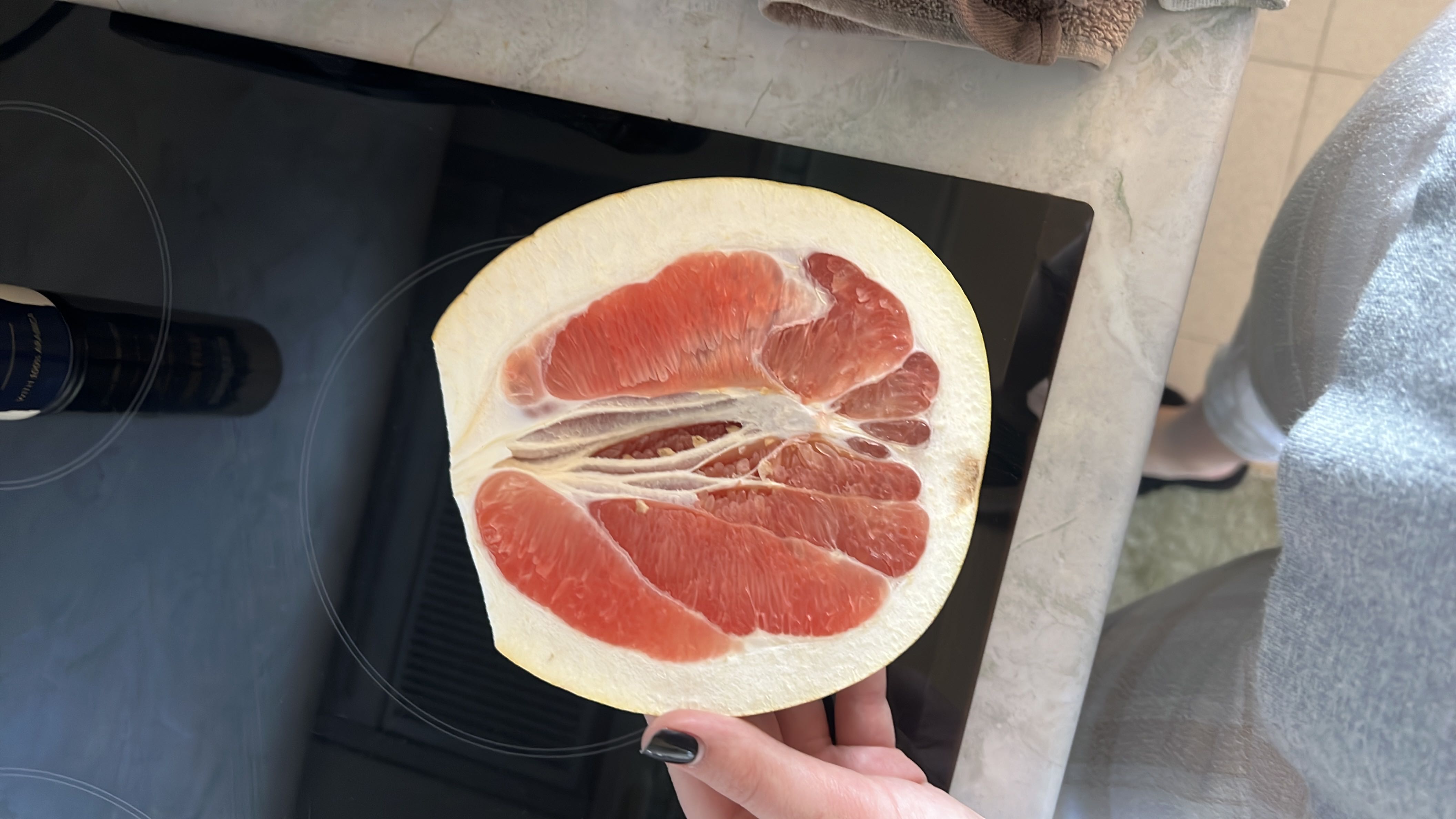 The image shows a halved grapefruit, a low-calorie fruit rich in vitamins and fiber.