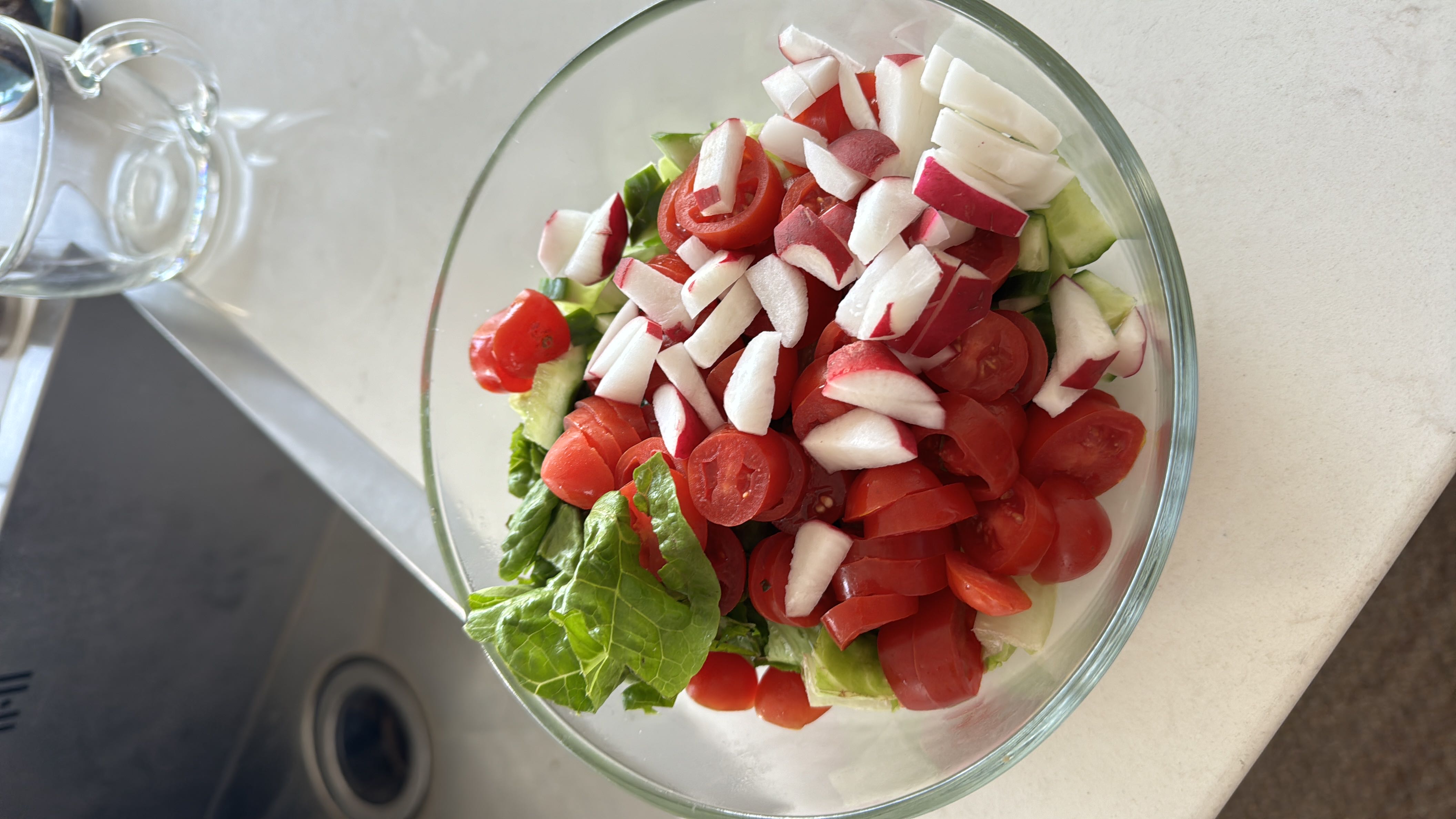 A fresh vegetable salad containing lettuce, cherry tomatoes, radishes, and cucumber, offering a low-calorie, nutrient-rich meal.