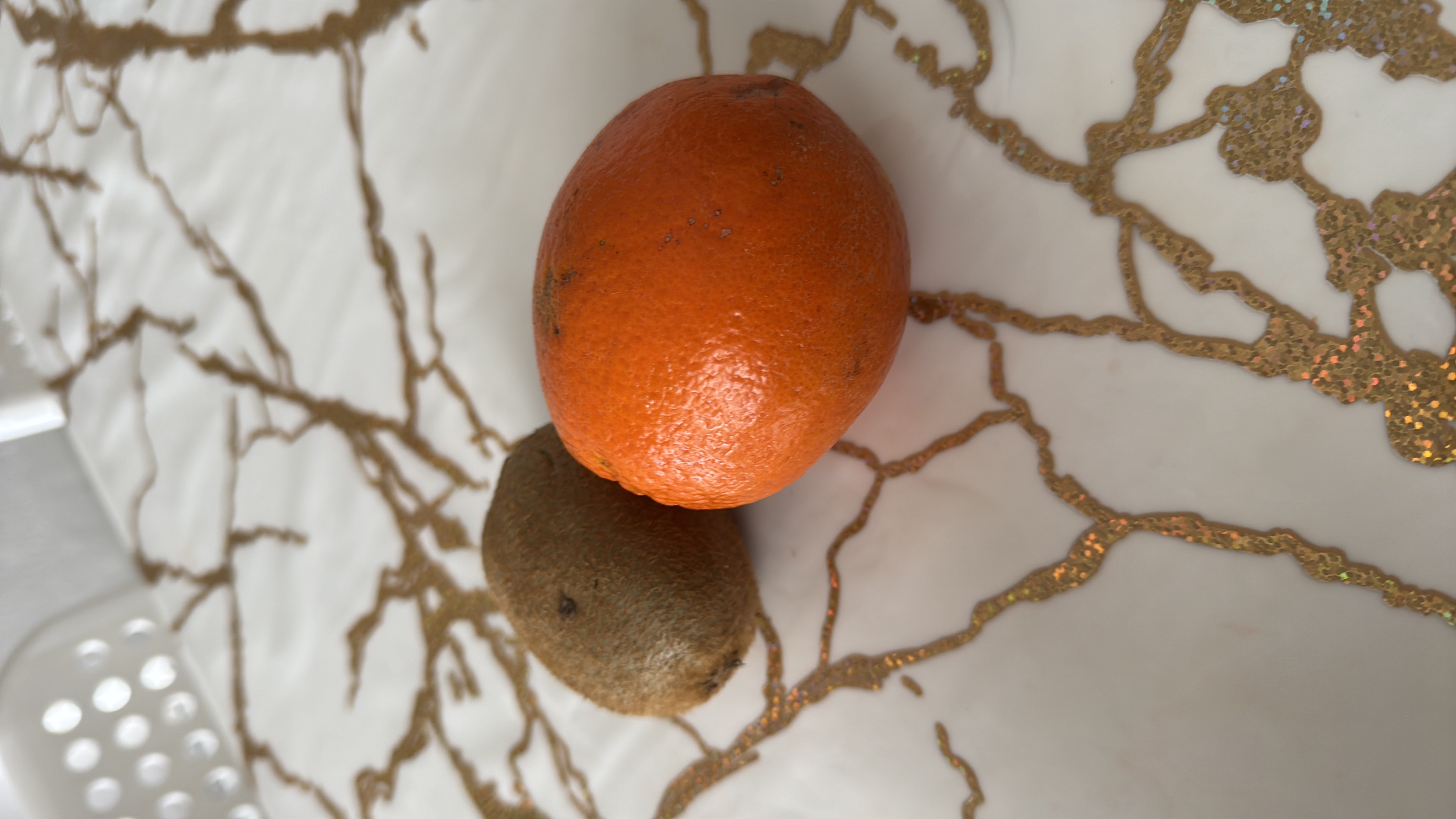 The image shows a kiwi and an orange, both of which are nutritious fruits rich in vitamins and low in fats.