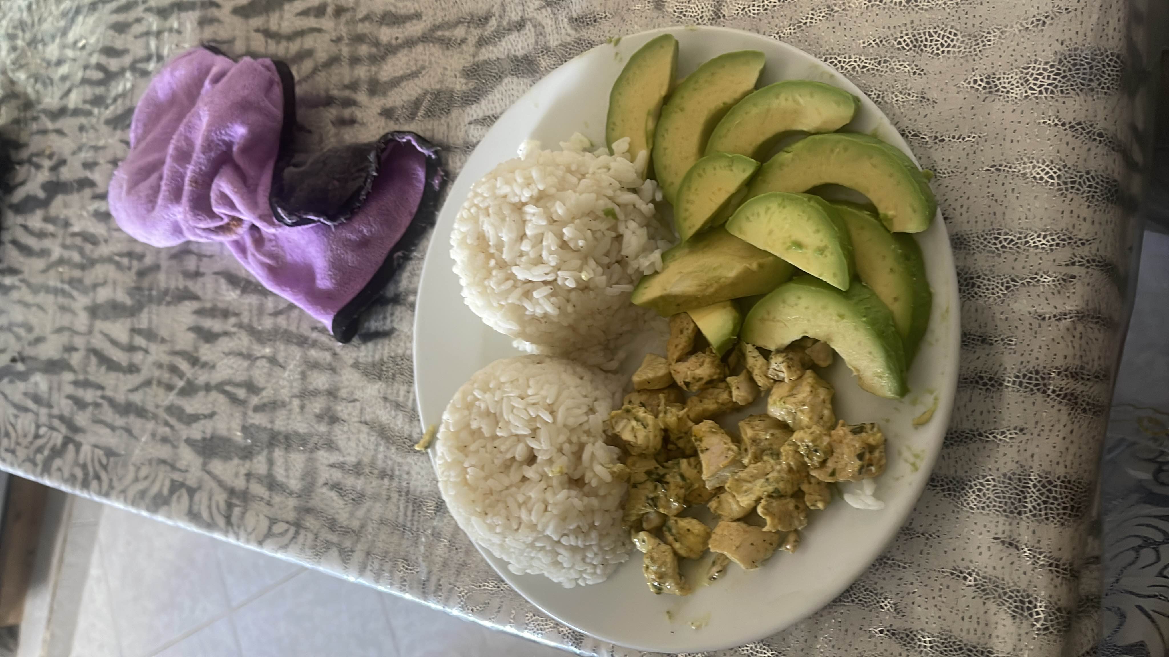 A balanced meal consisting of rice, chicken, and avocado slices, providing a good mix of carbohydrates, protein, and healthy fats.