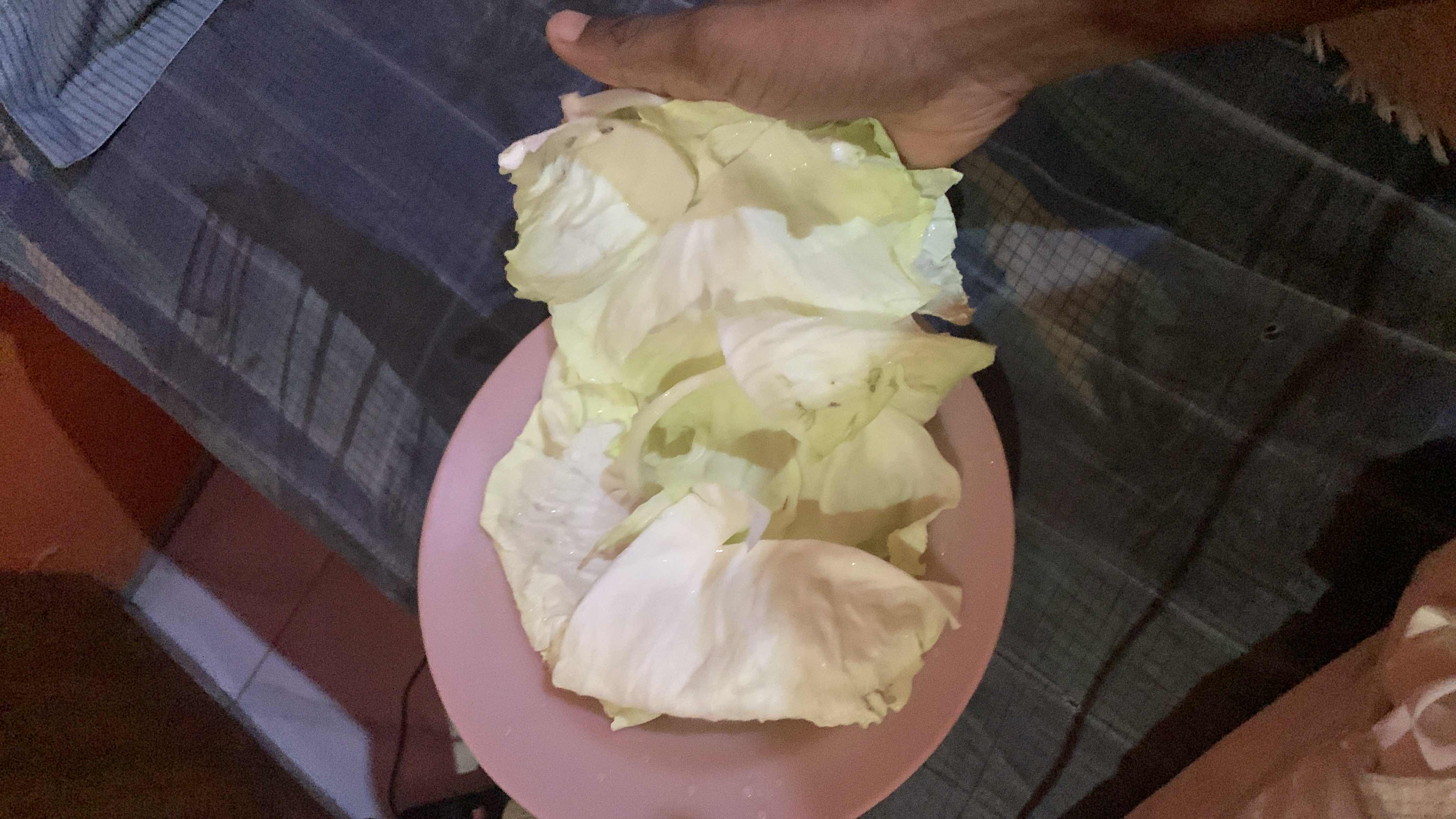 The image shows a plate of raw cabbage leaves, which are low in calories and rich in nutrients.