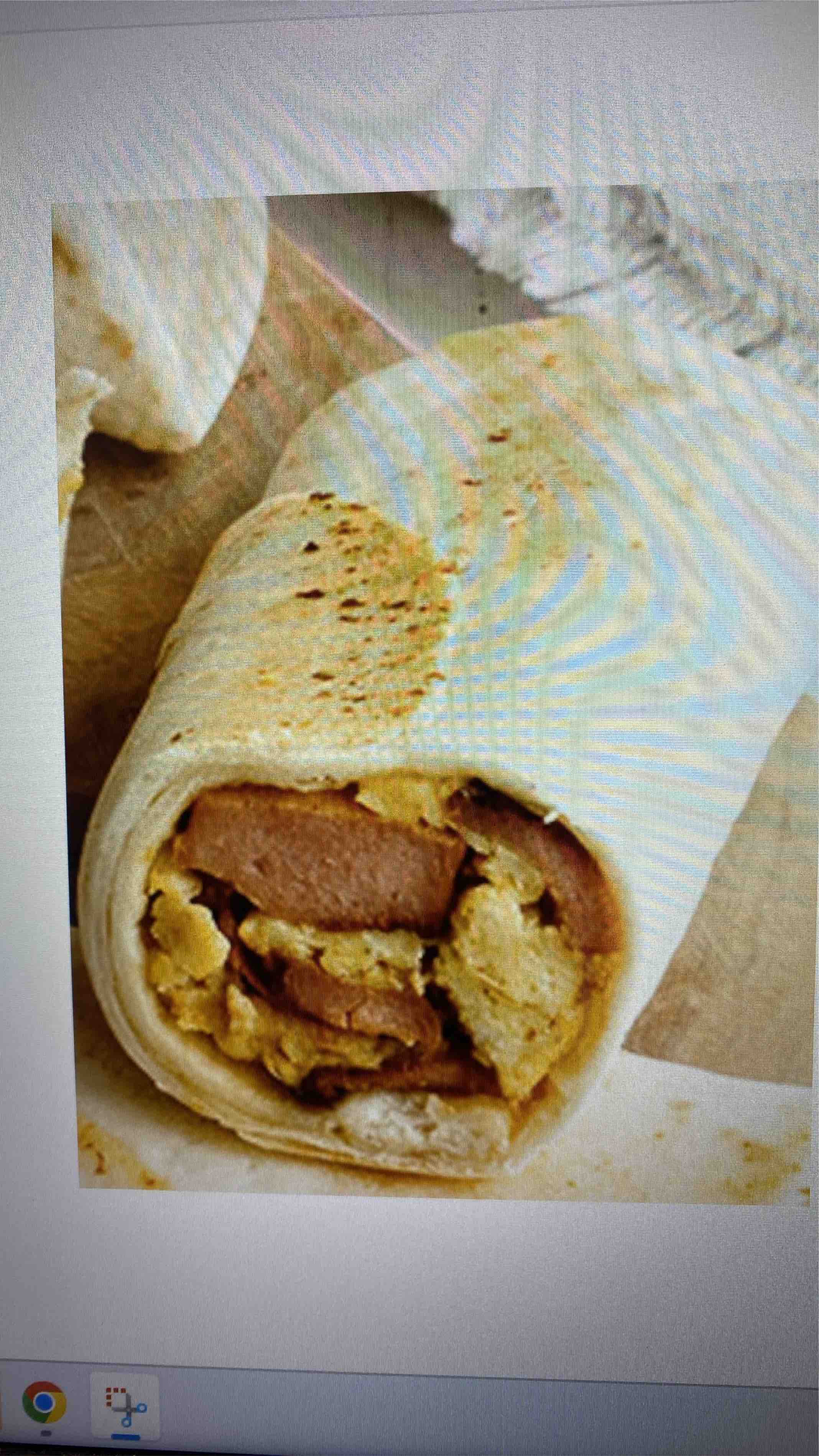 A wrap containing sausage, scrambled eggs, and tortilla, providing a balanced mix of protein, carbs, and fats.