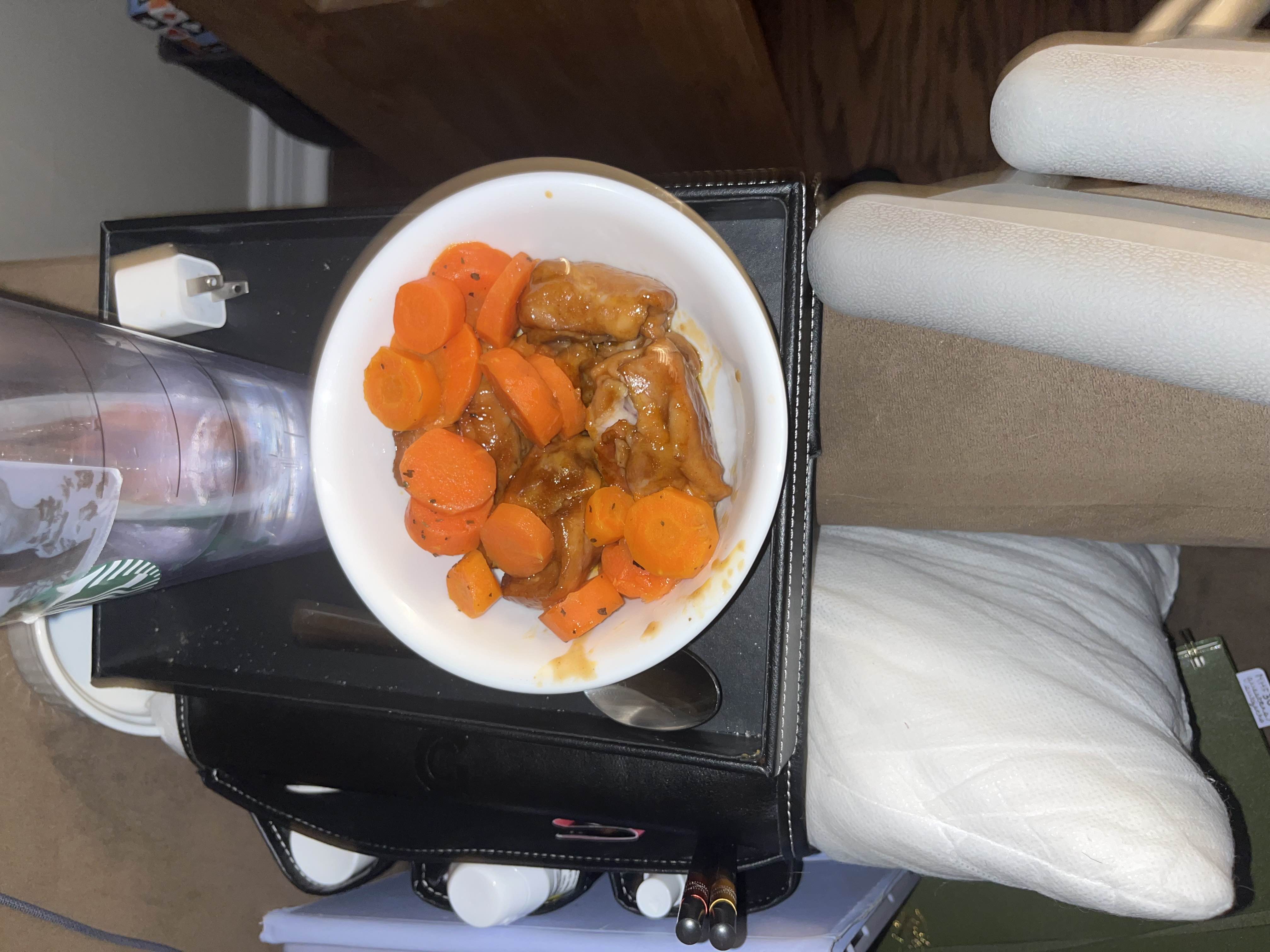 A dish consisting of cooked chicken, sliced carrots, and a savory sauce, providing a balanced mix of protein, carbs, and fats.
