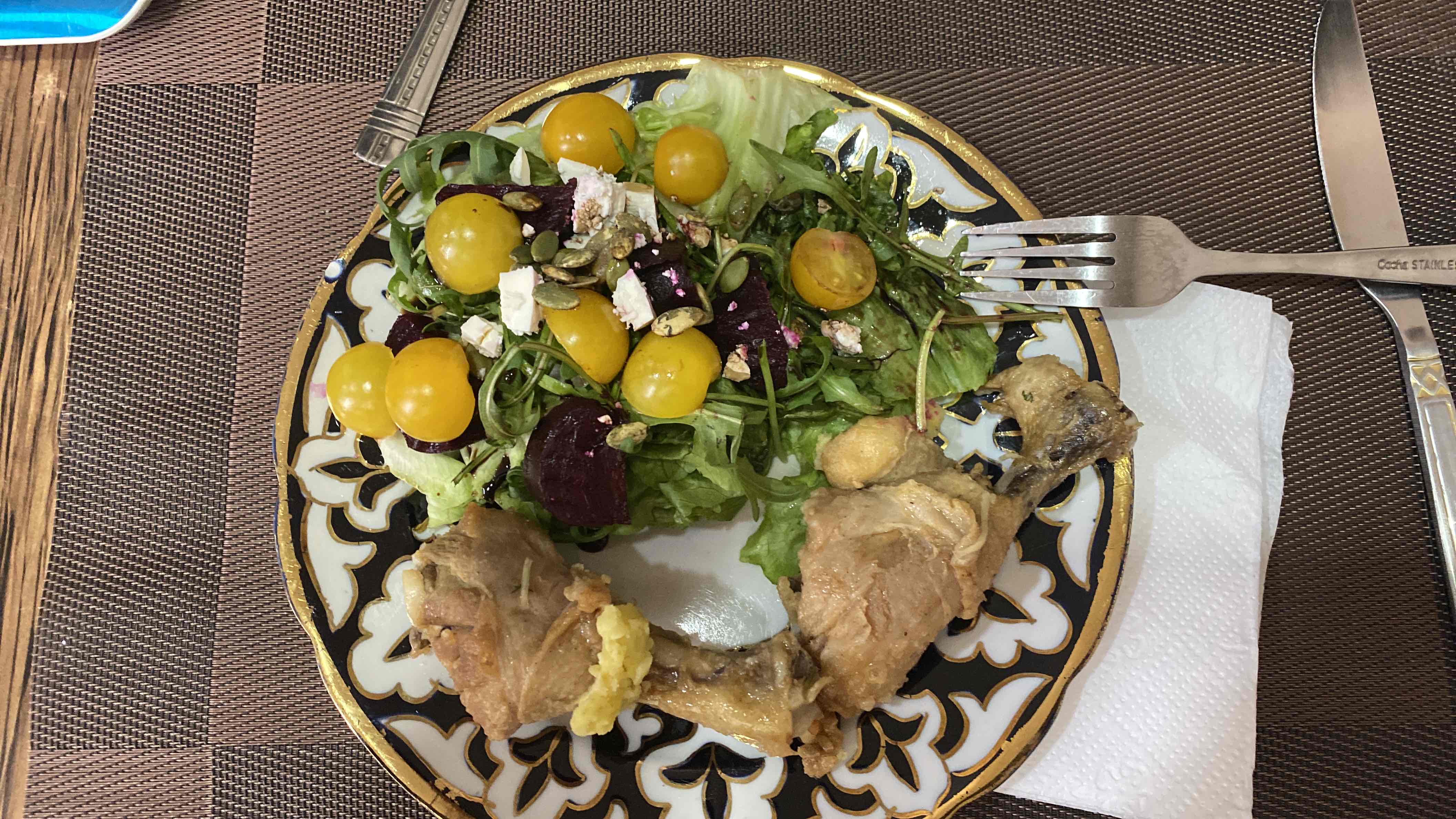 A balanced meal consisting of roasted chicken and a fresh salad with arugula, yellow cherry tomatoes, beetroot, feta cheese, pumpkin seeds, and lettuce.