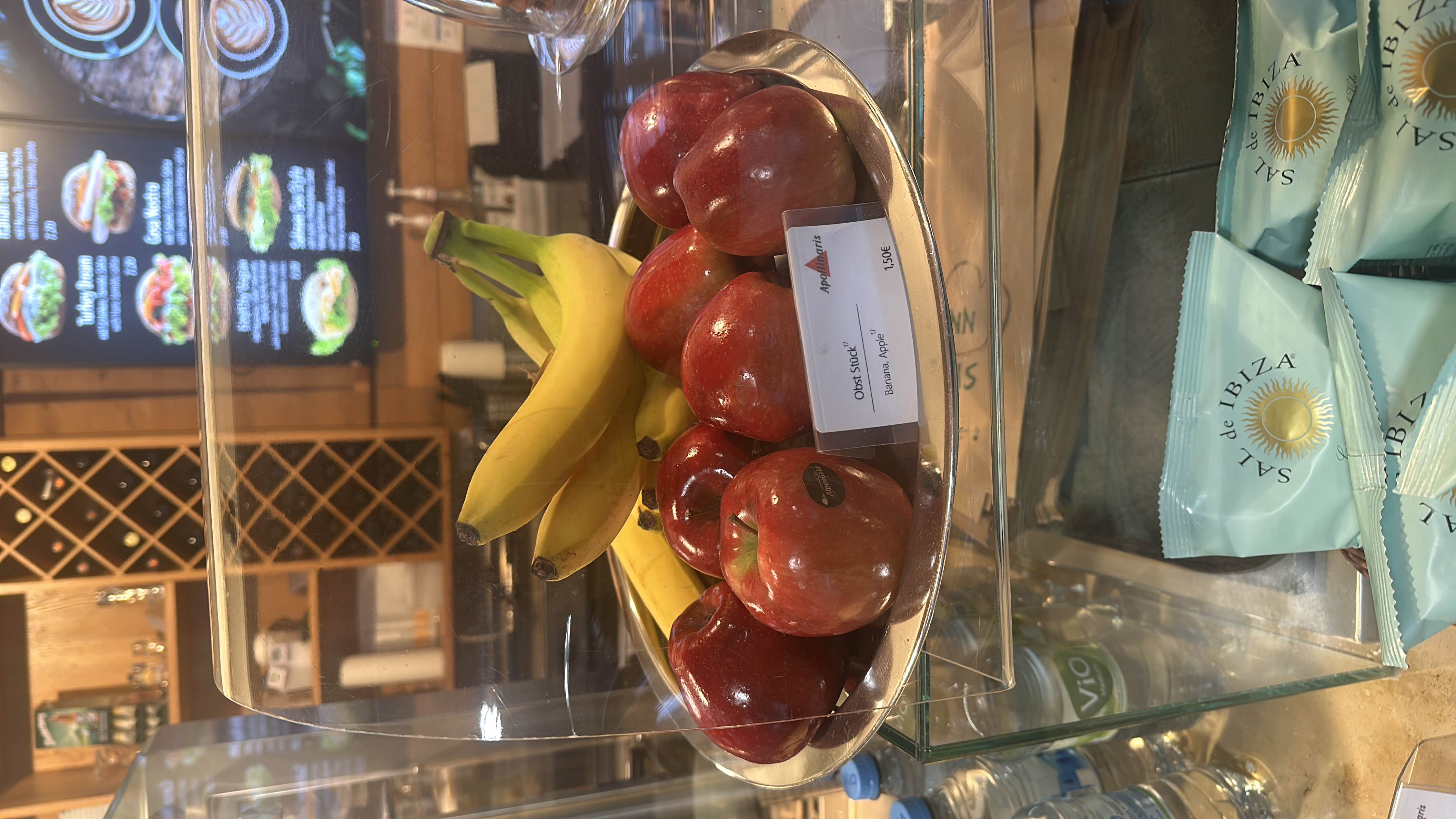 A display of fresh bananas and apples, offering a healthy snack option with minimal fats and high carbohydrate content.