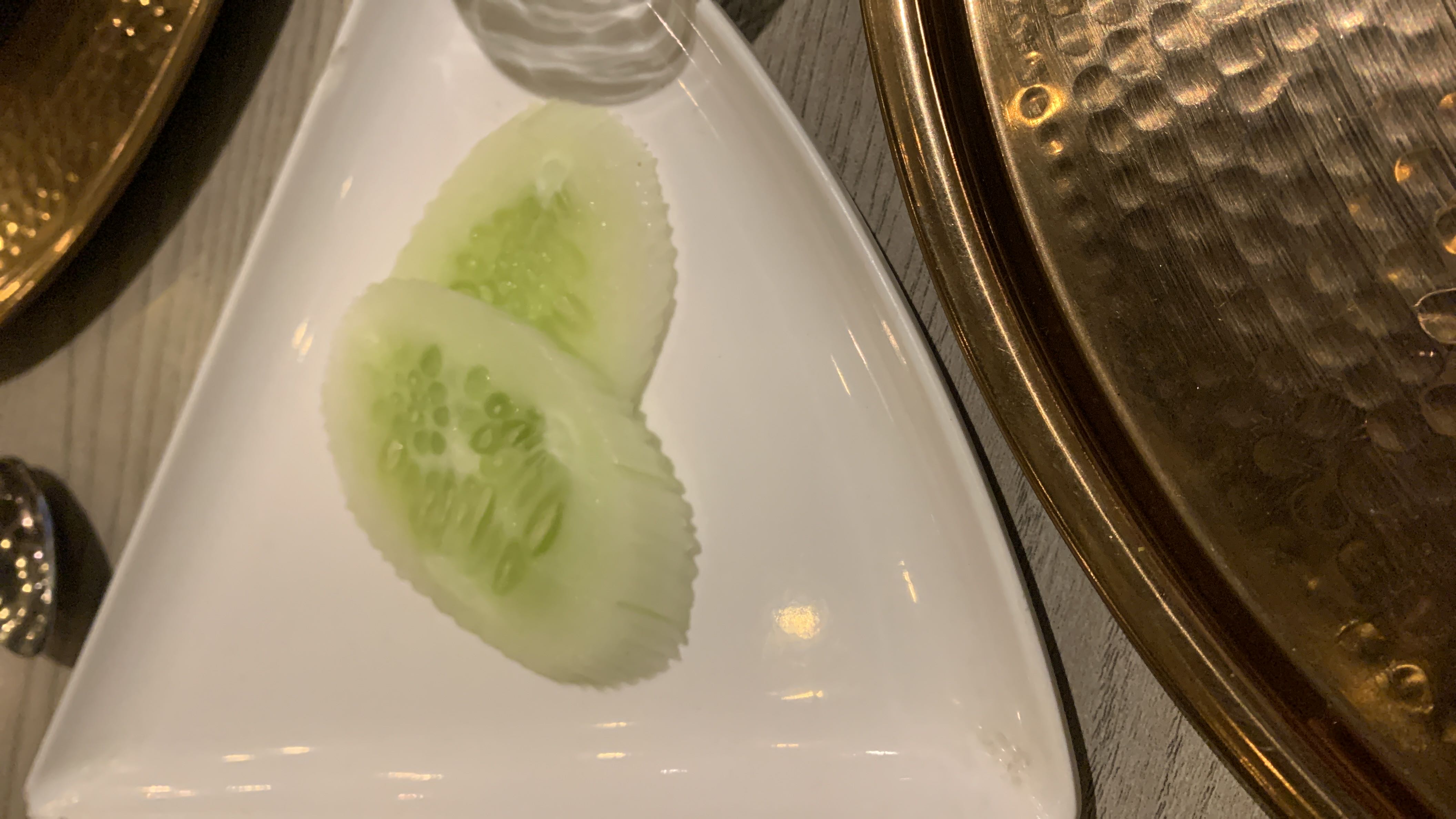 The image shows two slices of cucumber on a white plate, which are low in calories and high in water content.