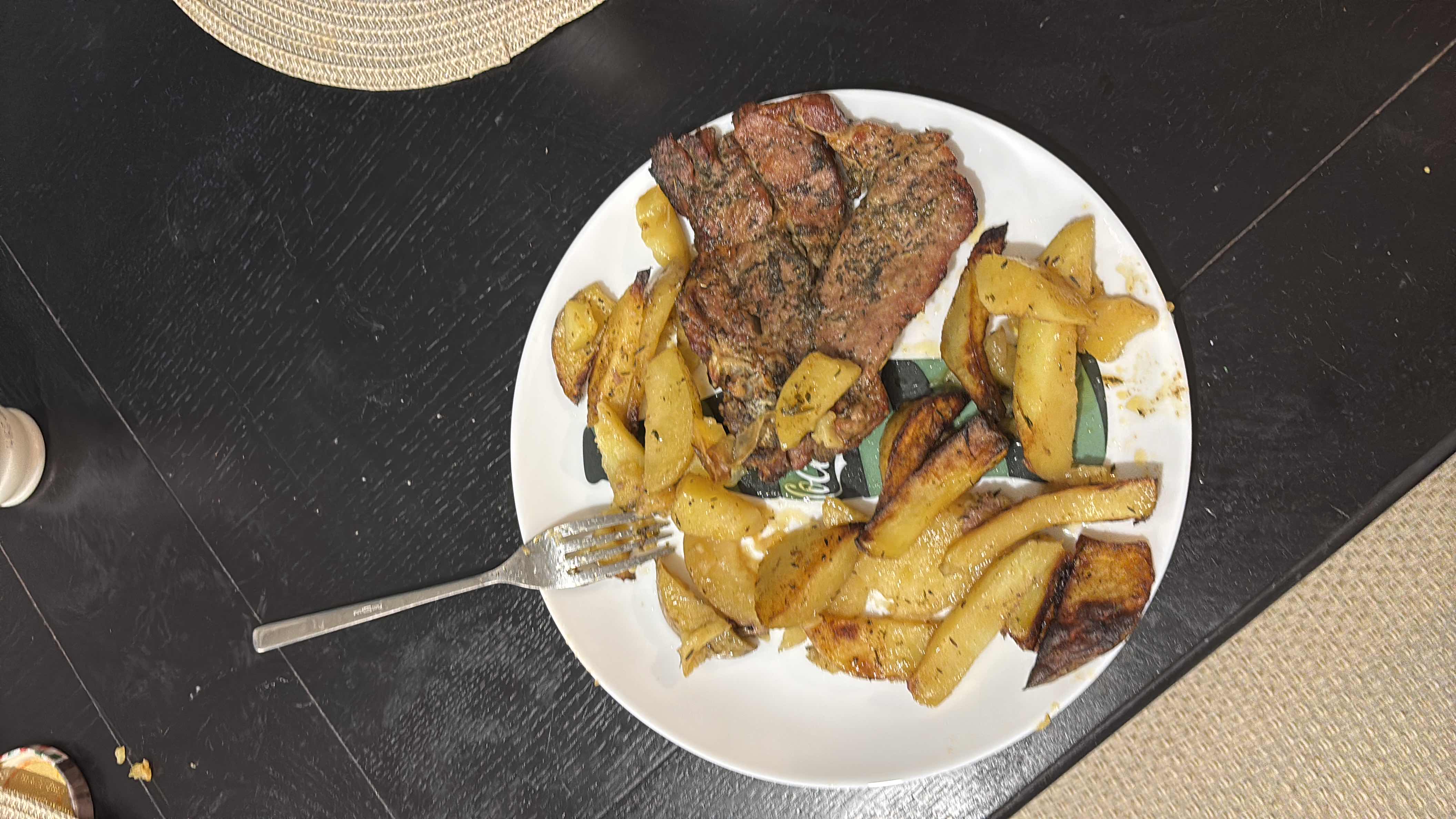 A plate containing grilled meat and roasted potatoes, providing a balanced mix of protein, carbs, and fats.