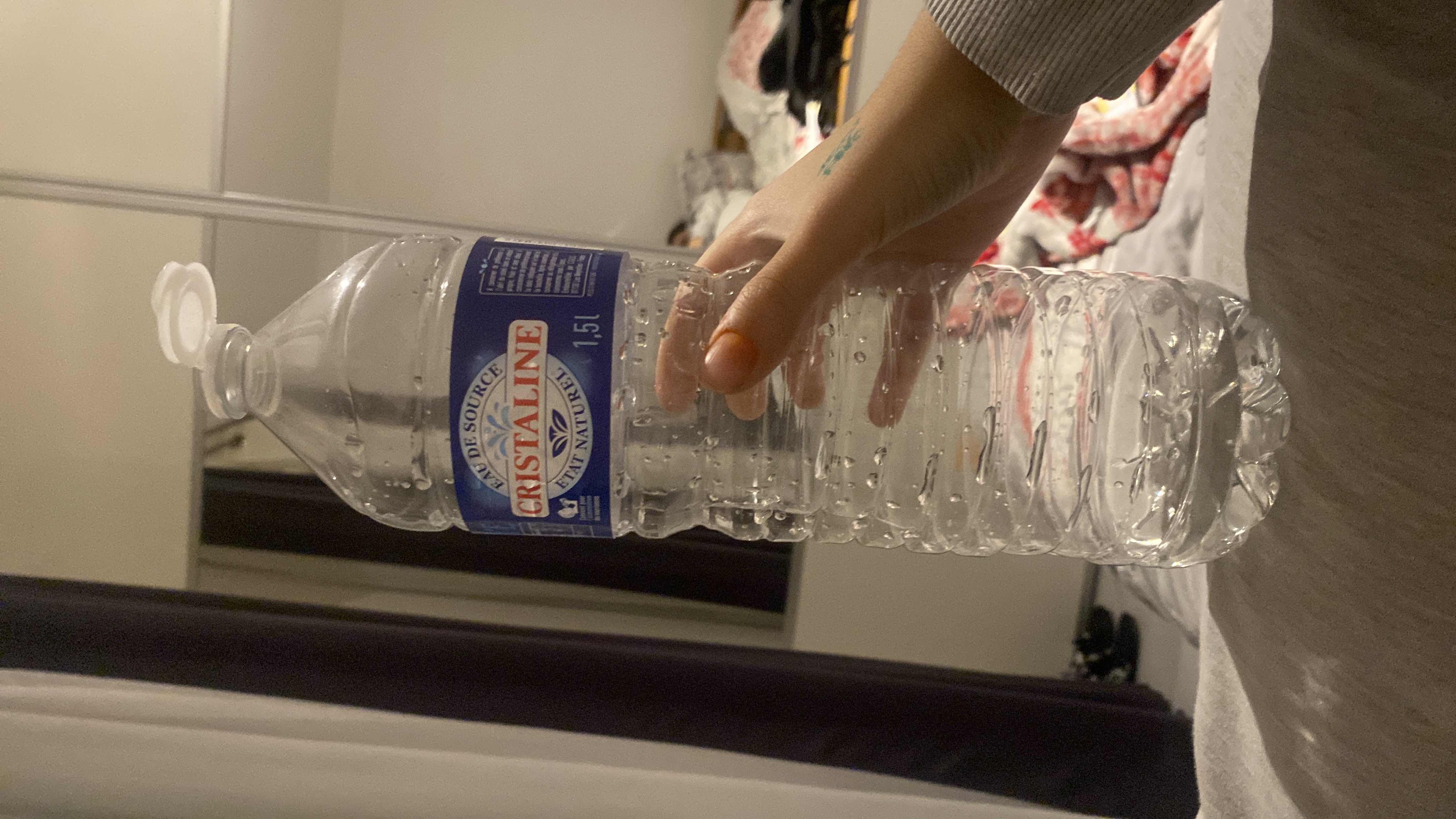 The image shows a bottle of Cristaline natural mineral water, which contains no calories, protein, carbs, or fats.