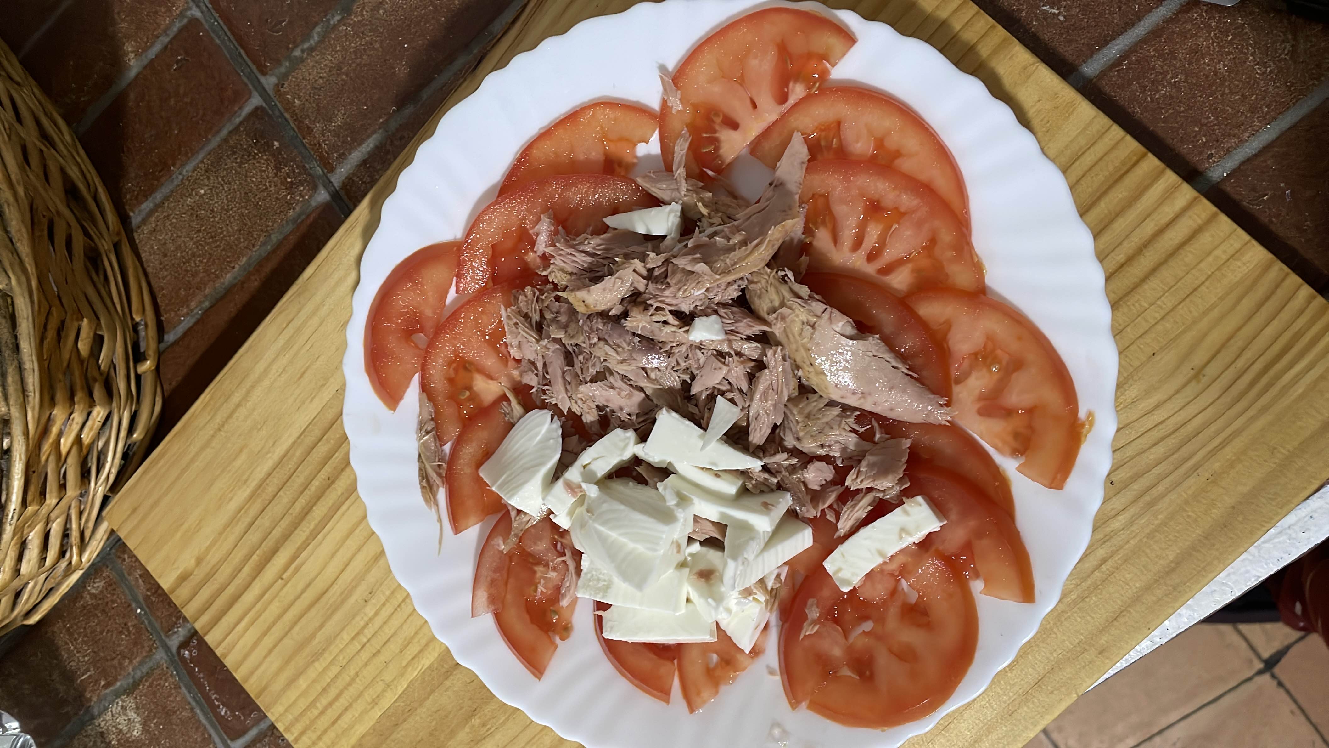 A fresh and healthy dish consisting of sliced tomatoes, tuna, and mozzarella cheese, providing a balanced mix of protein, fats, and carbohydrates.