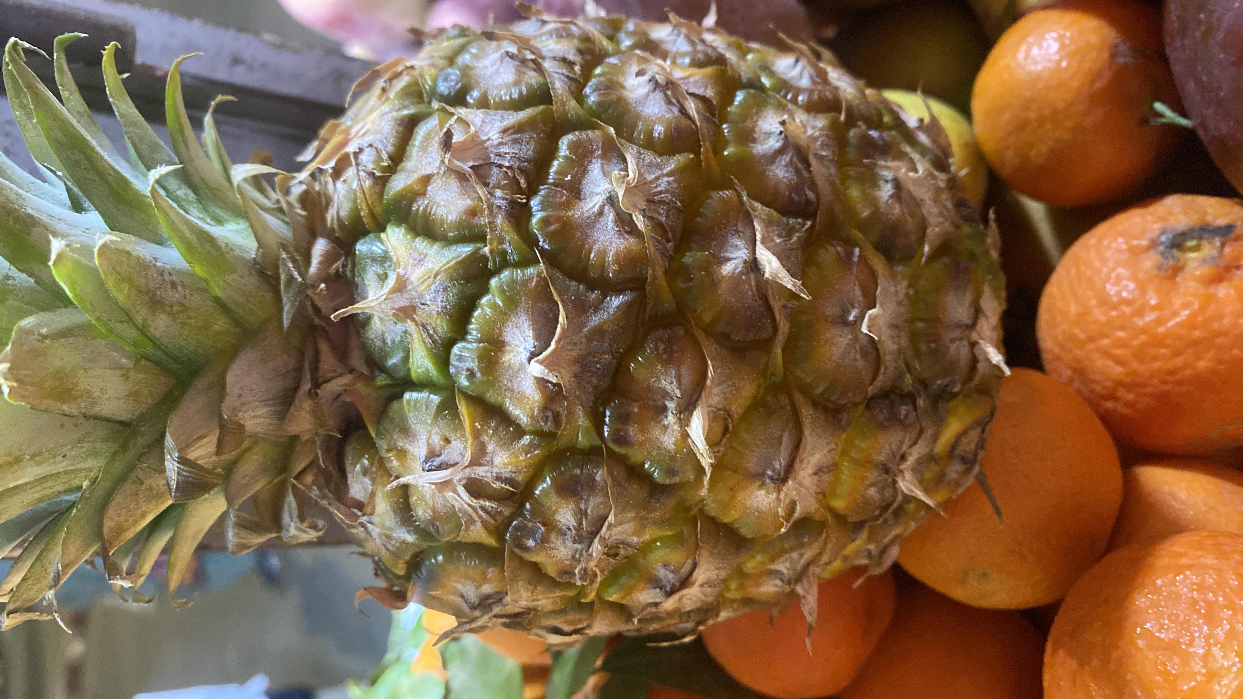 The image shows a fresh pineapple, a tropical fruit rich in vitamins and low in calories, commonly used in healthy diets.