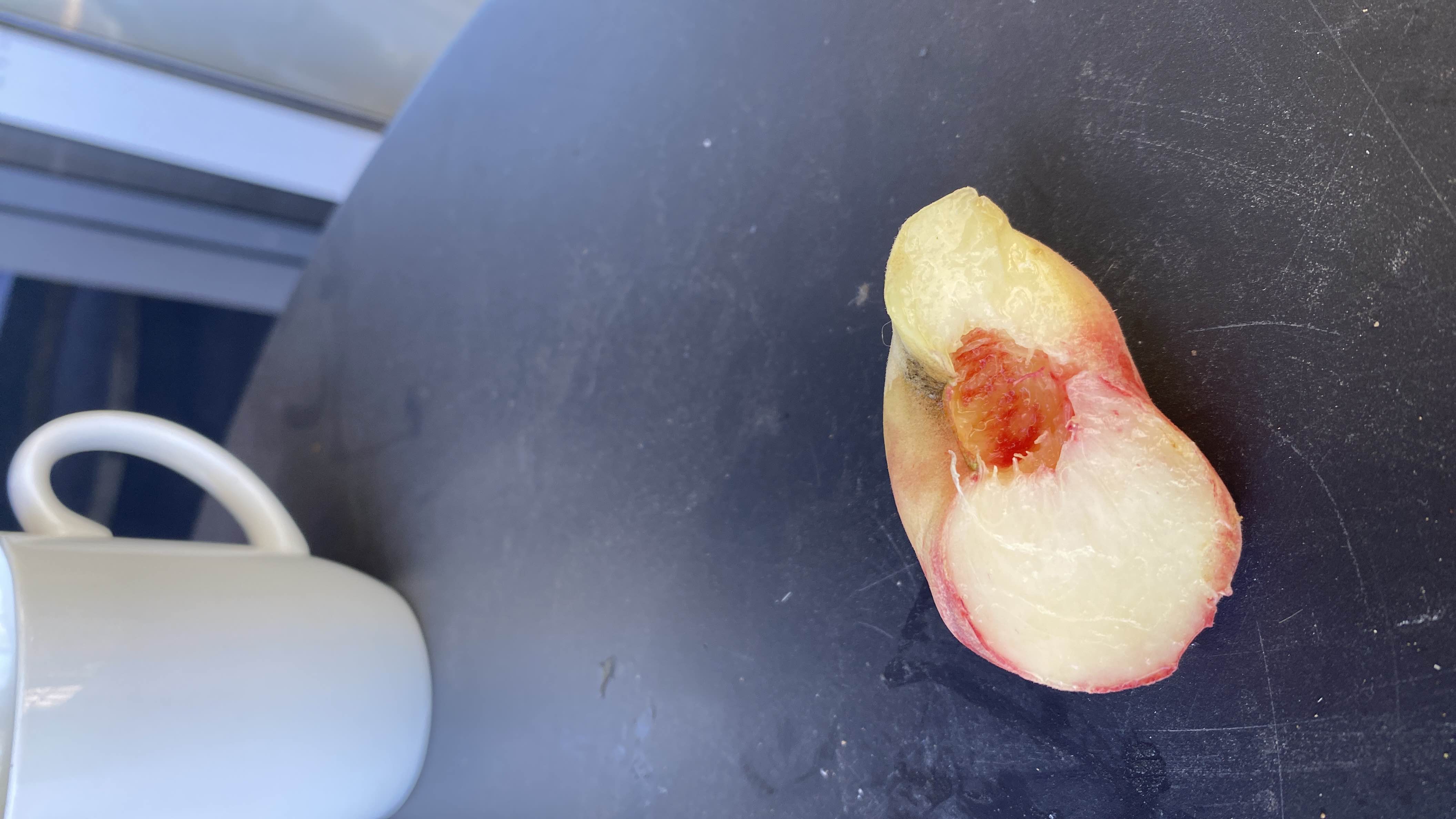 The image shows a halved peach, a low-calorie fruit rich in carbohydrates and minimal fats, making it a healthy snack option.