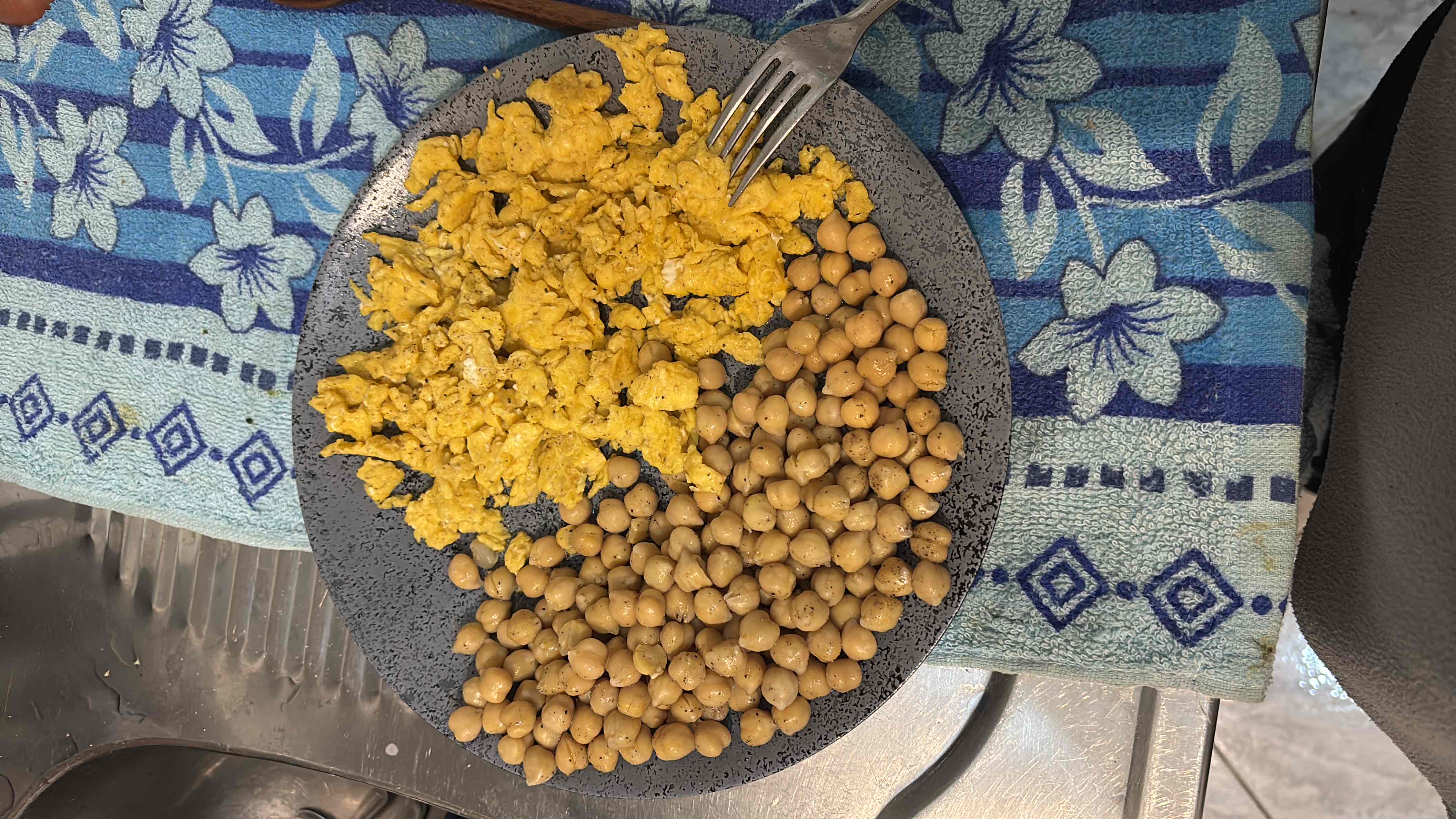 A plate containing chickpeas and scrambled eggs, providing a balanced mix of protein, carbs, and fats.