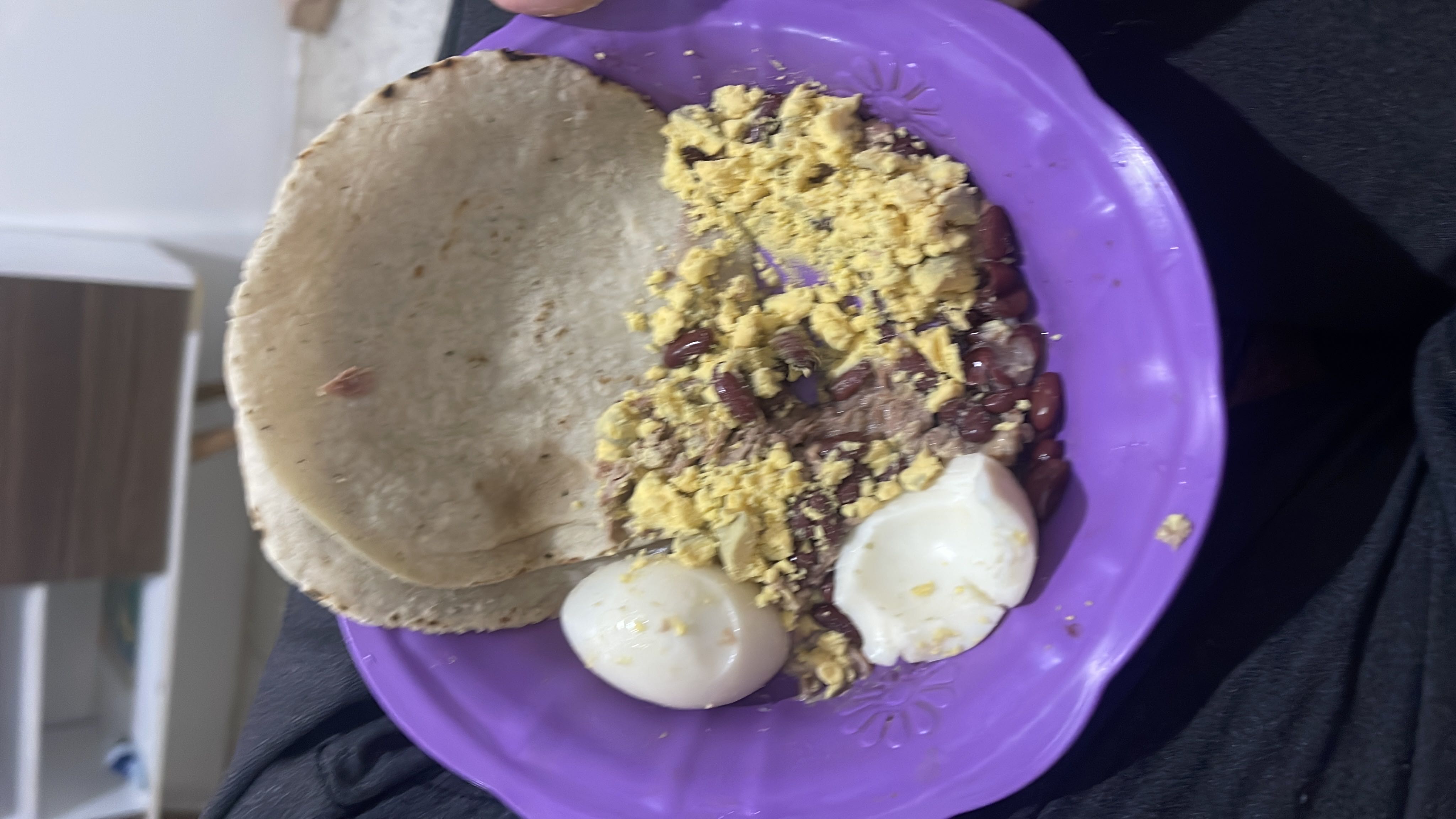 A meal consisting of boiled eggs, beans, and tortillas, providing a balanced mix of protein, carbs, and fats.