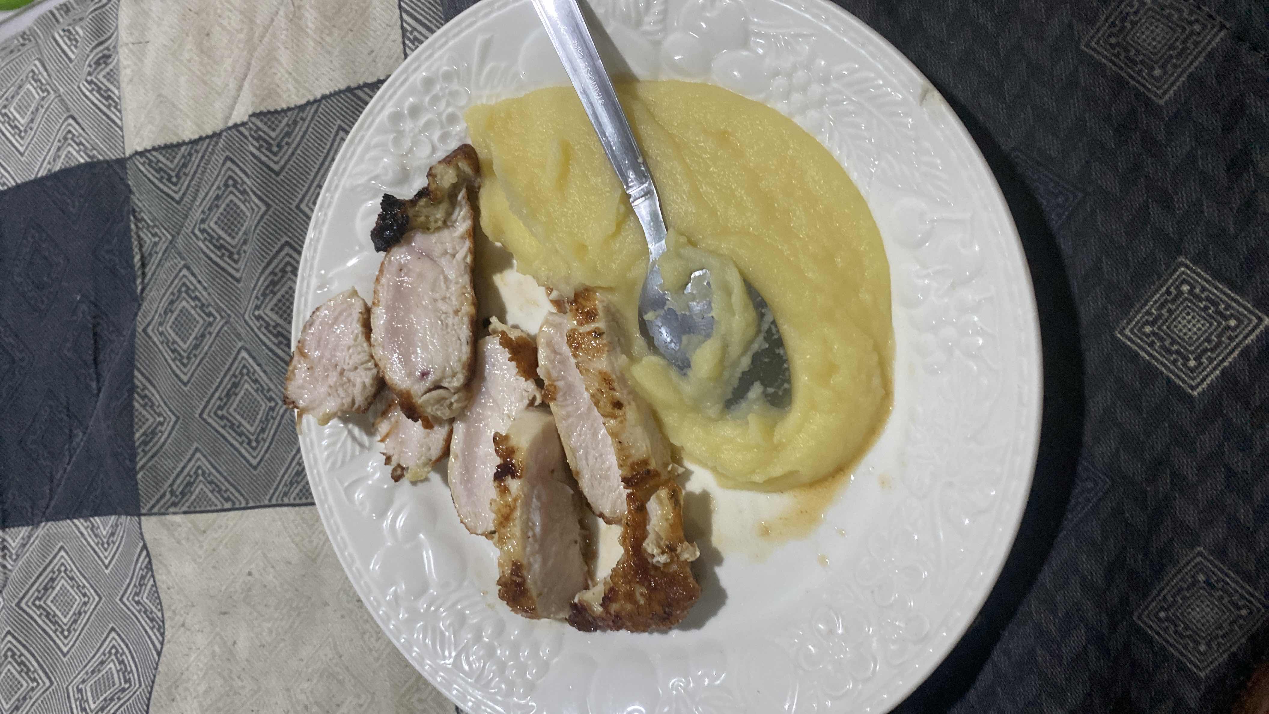 A plate of grilled chicken slices served with mashed potatoes, providing a balanced mix of protein, carbs, and fats.