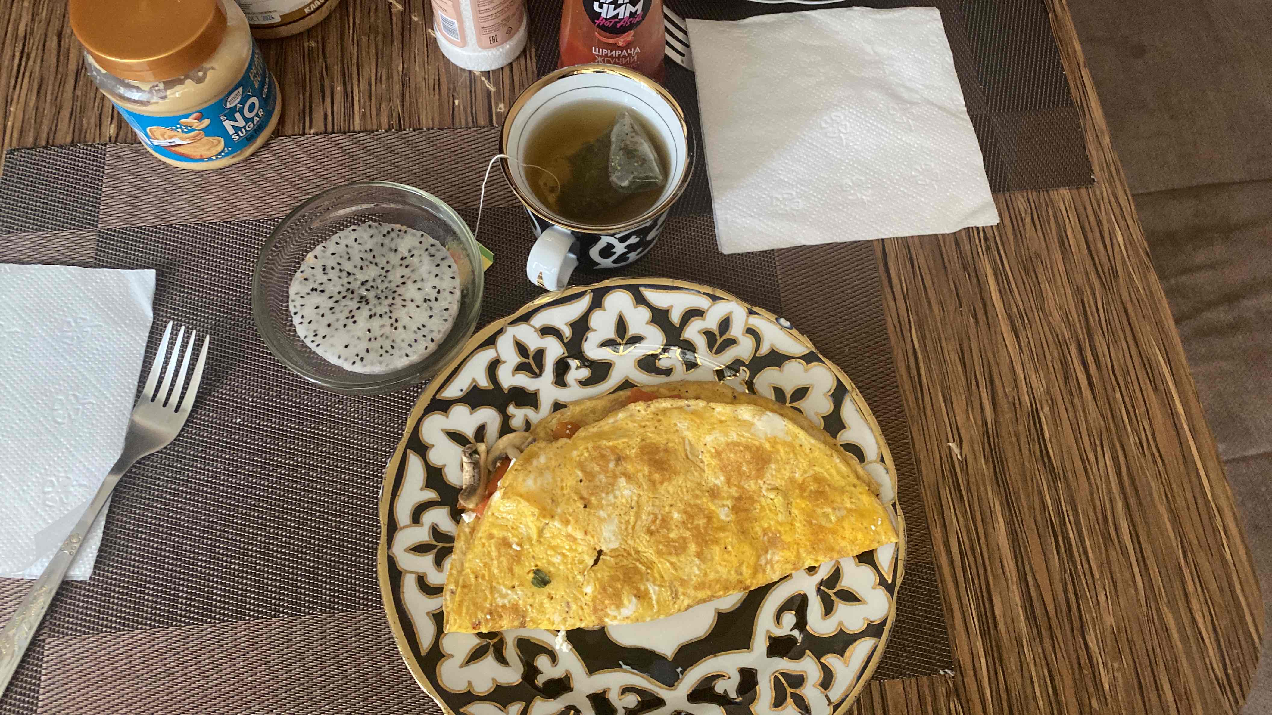 A balanced breakfast featuring an omelette with red pepper, mushrooms, and feta cheese, dragon fruit, and green tea.
