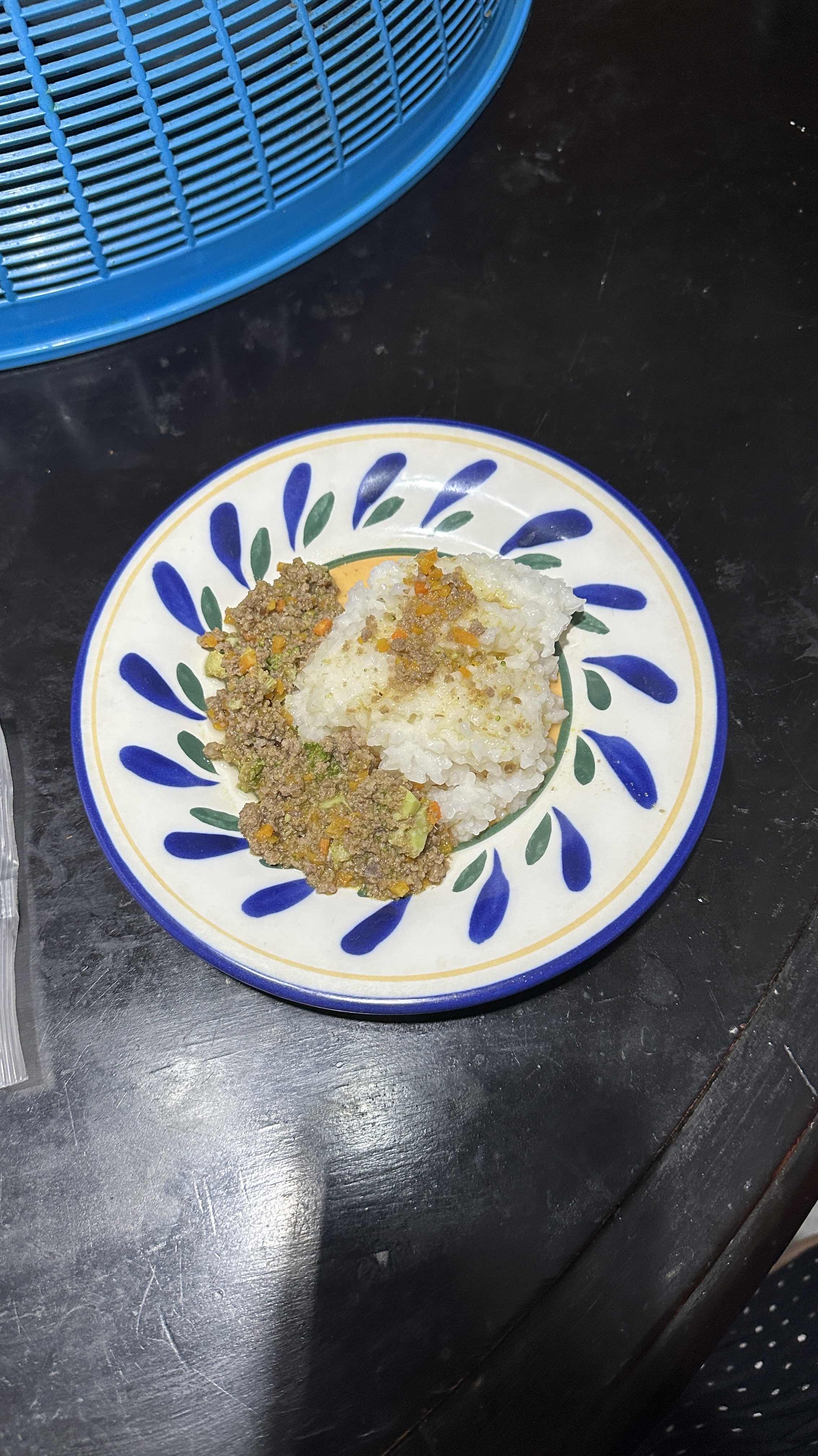 A plate of rice served with ground meat and mixed vegetables, providing a balanced mix of carbohydrates, protein, and fats.