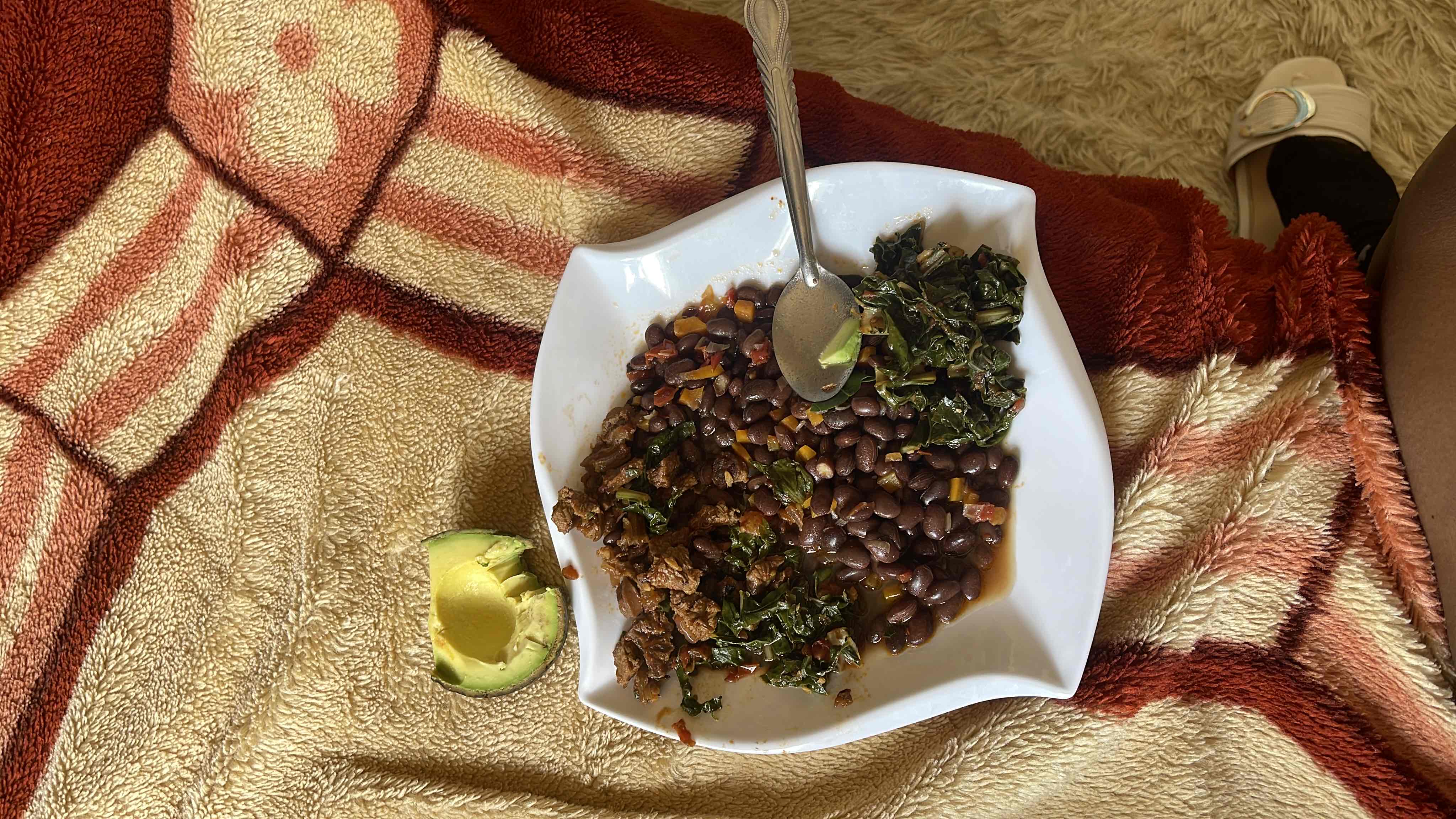 A nutritious meal consisting of black beans, beef, kale, and avocado, providing a balanced mix of protein, carbs, and healthy fats.