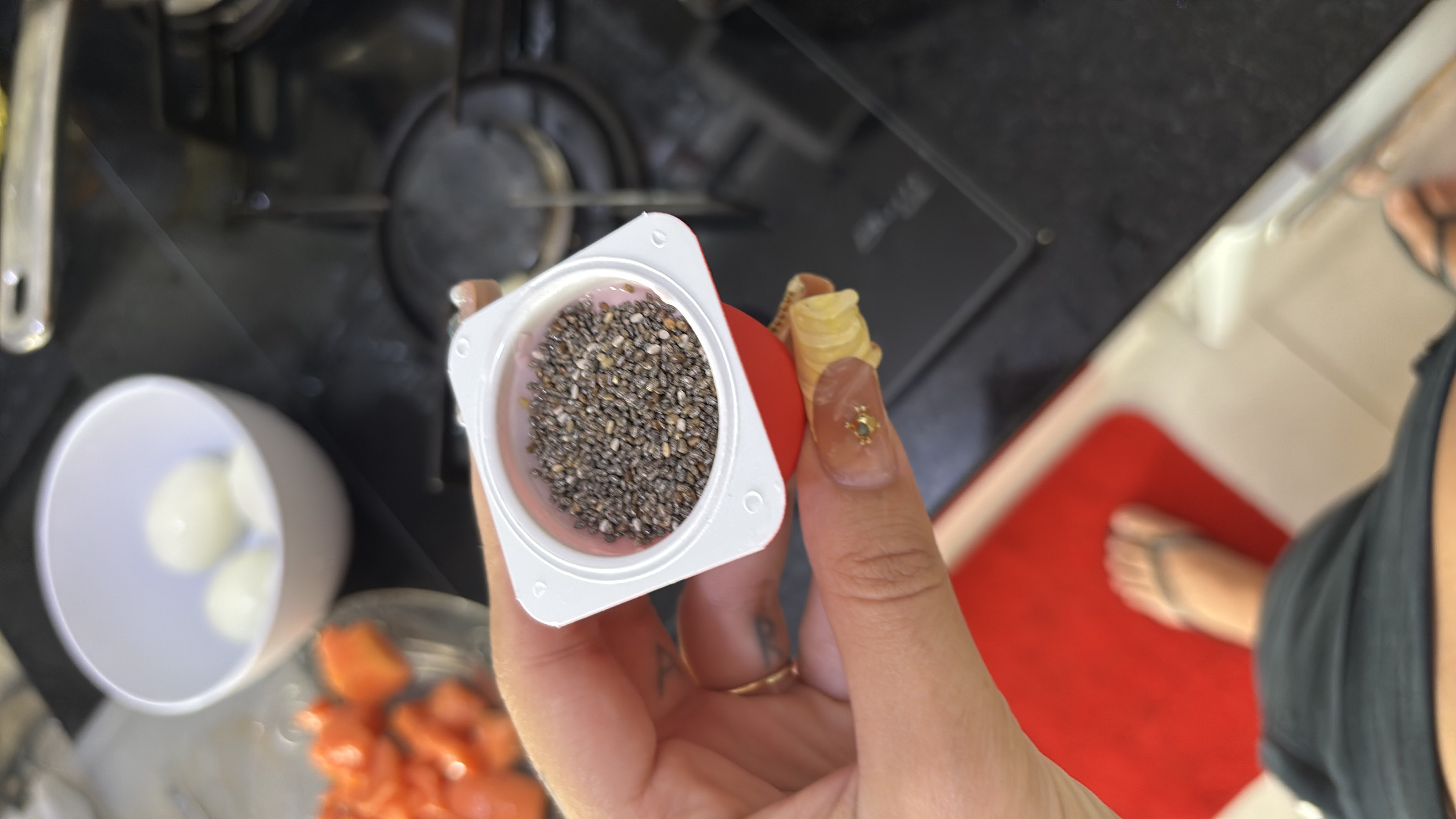 The image shows a small container of chia seeds, a bowl of boiled eggs, diced papaya, and yogurt, suggesting a healthy and balanced meal.