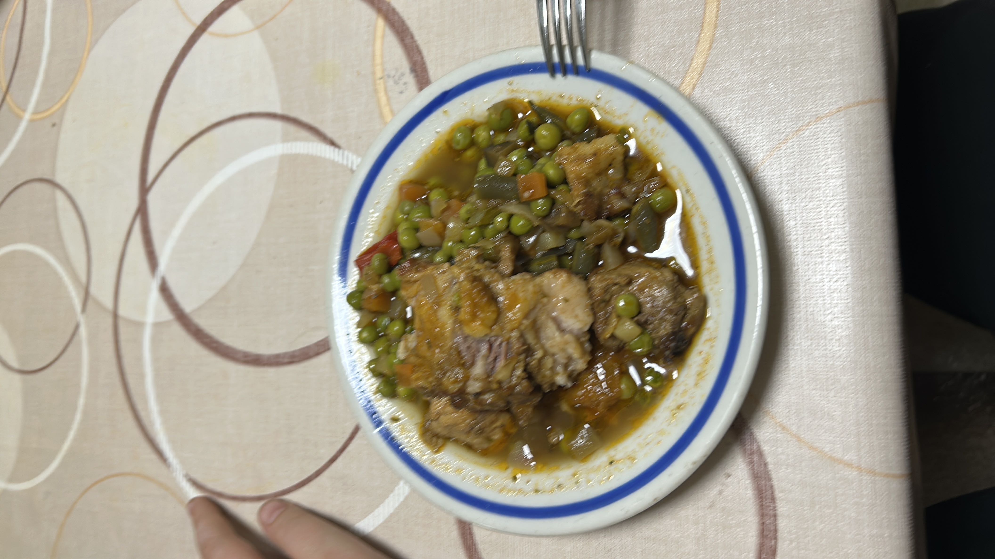 A nutritious dish consisting of chicken, peas, carrots, and green beans in a light sauce.