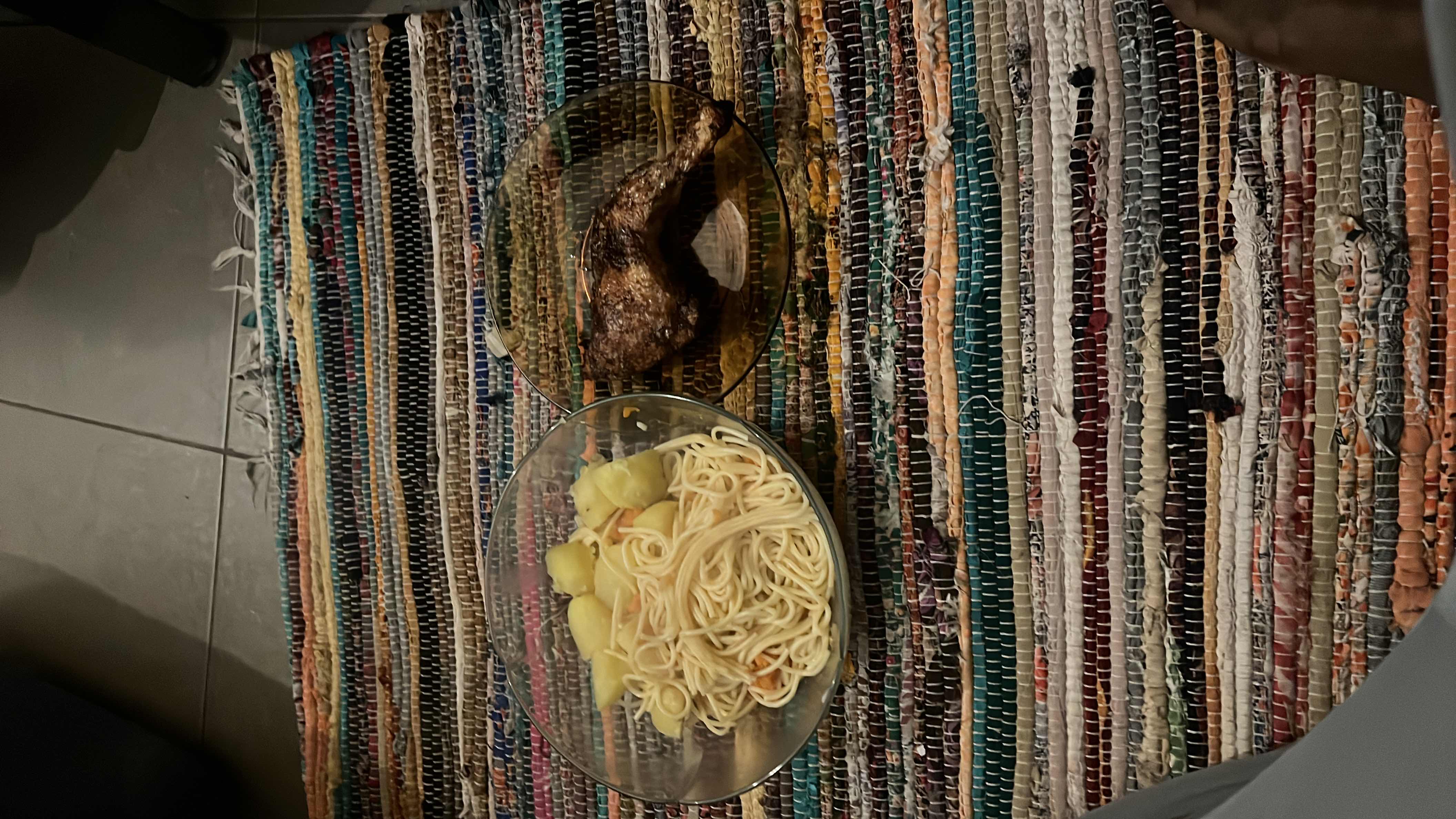 A meal consisting of spaghetti, boiled potatoes, and a grilled chicken leg, providing a balanced mix of protein, carbs, and fats.