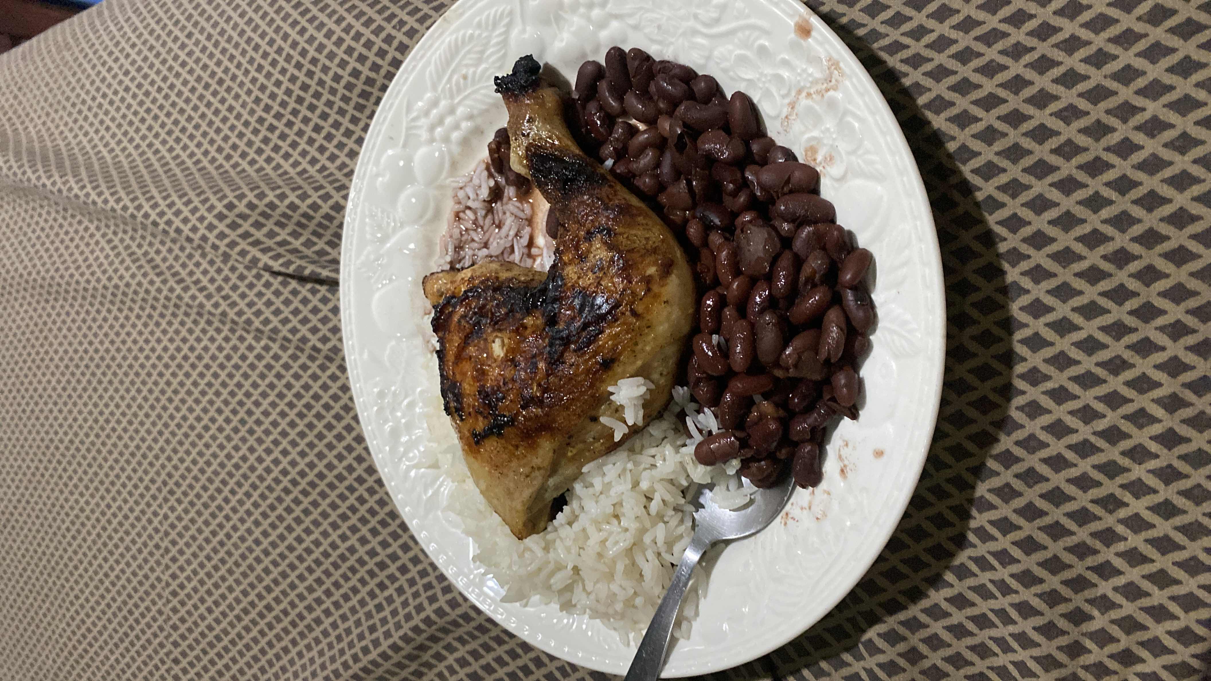 A balanced meal consisting of grilled chicken, white rice, and red beans, providing a good mix of protein, carbohydrates, and fats.