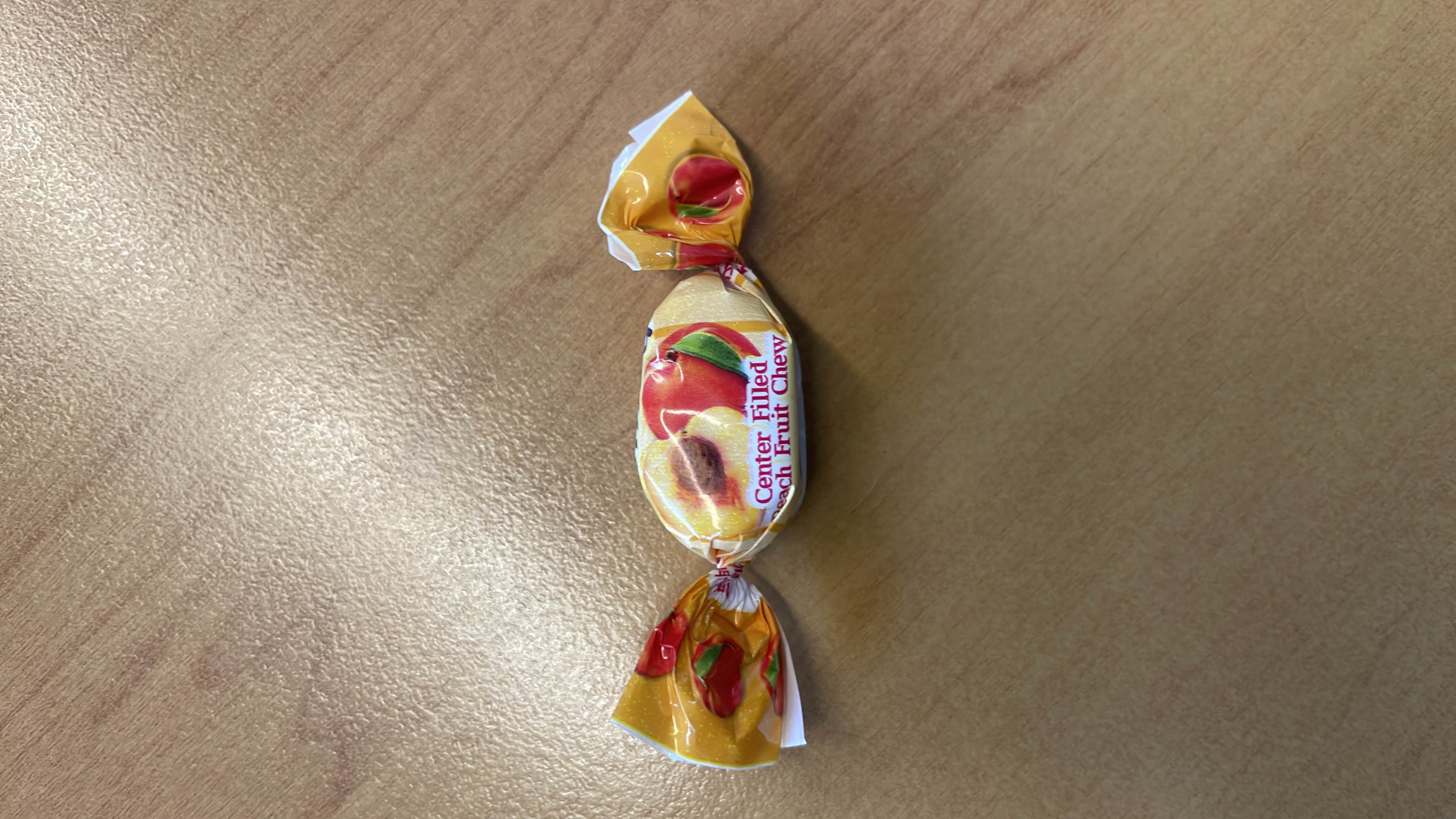 A center-filled peach-flavored fruit chew candy with a sweet and tangy taste.