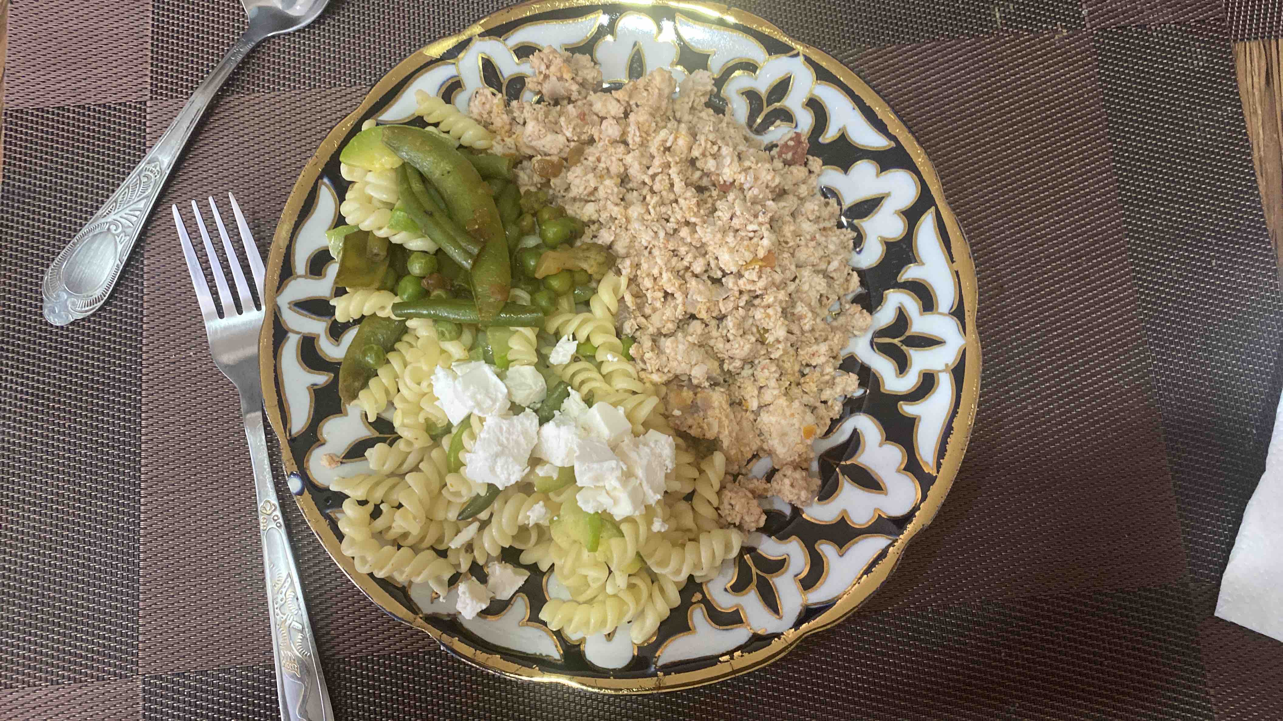 A balanced meal consisting of 118g pasta with 15g queso feta and zucchini, 160g chicken with onion, and 47g peas with green beans, totaling 560 calories.