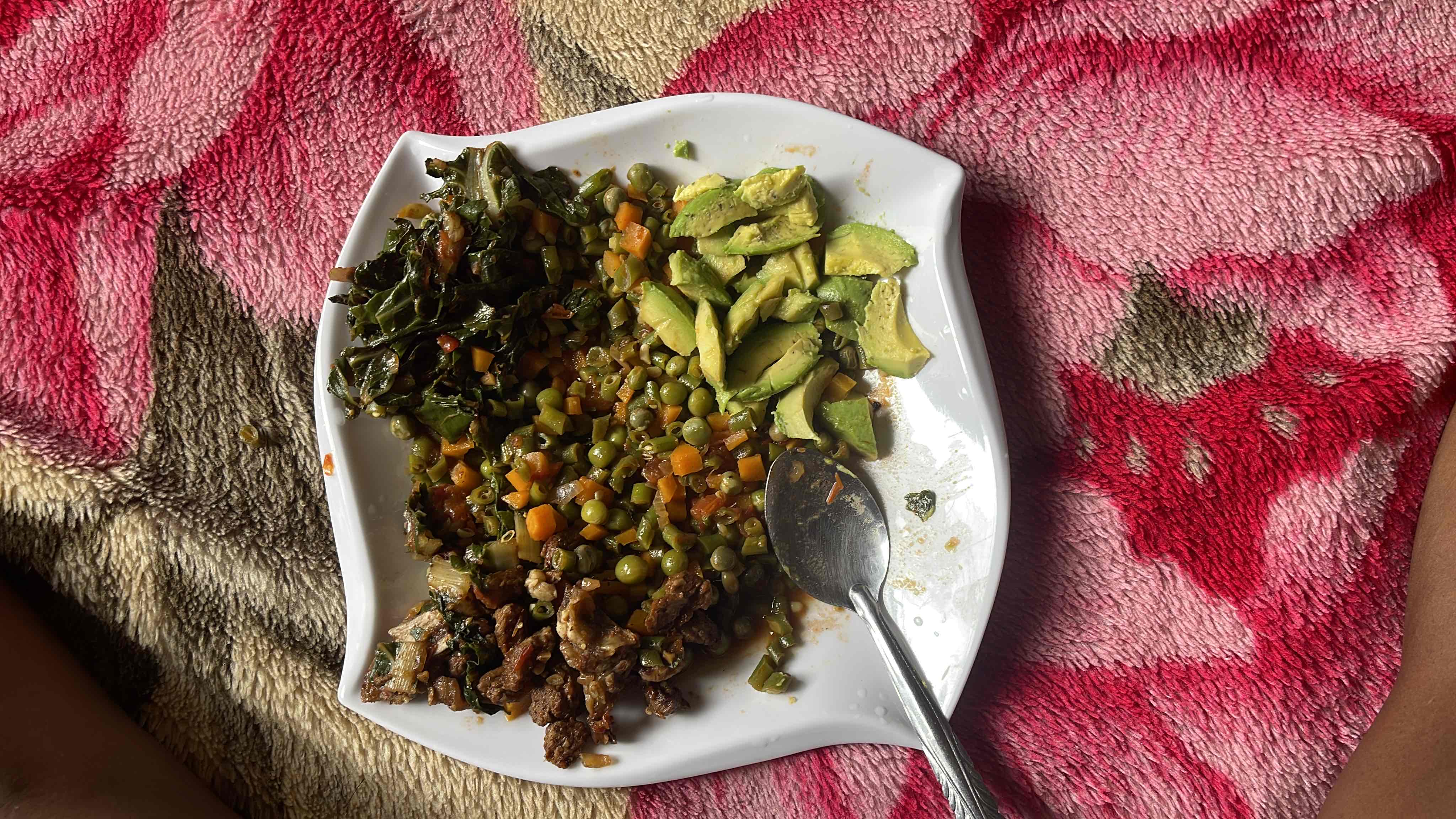 A balanced meal consisting of beef, mixed vegetables, and avocado, providing a good mix of protein, healthy fats, and carbohydrates.