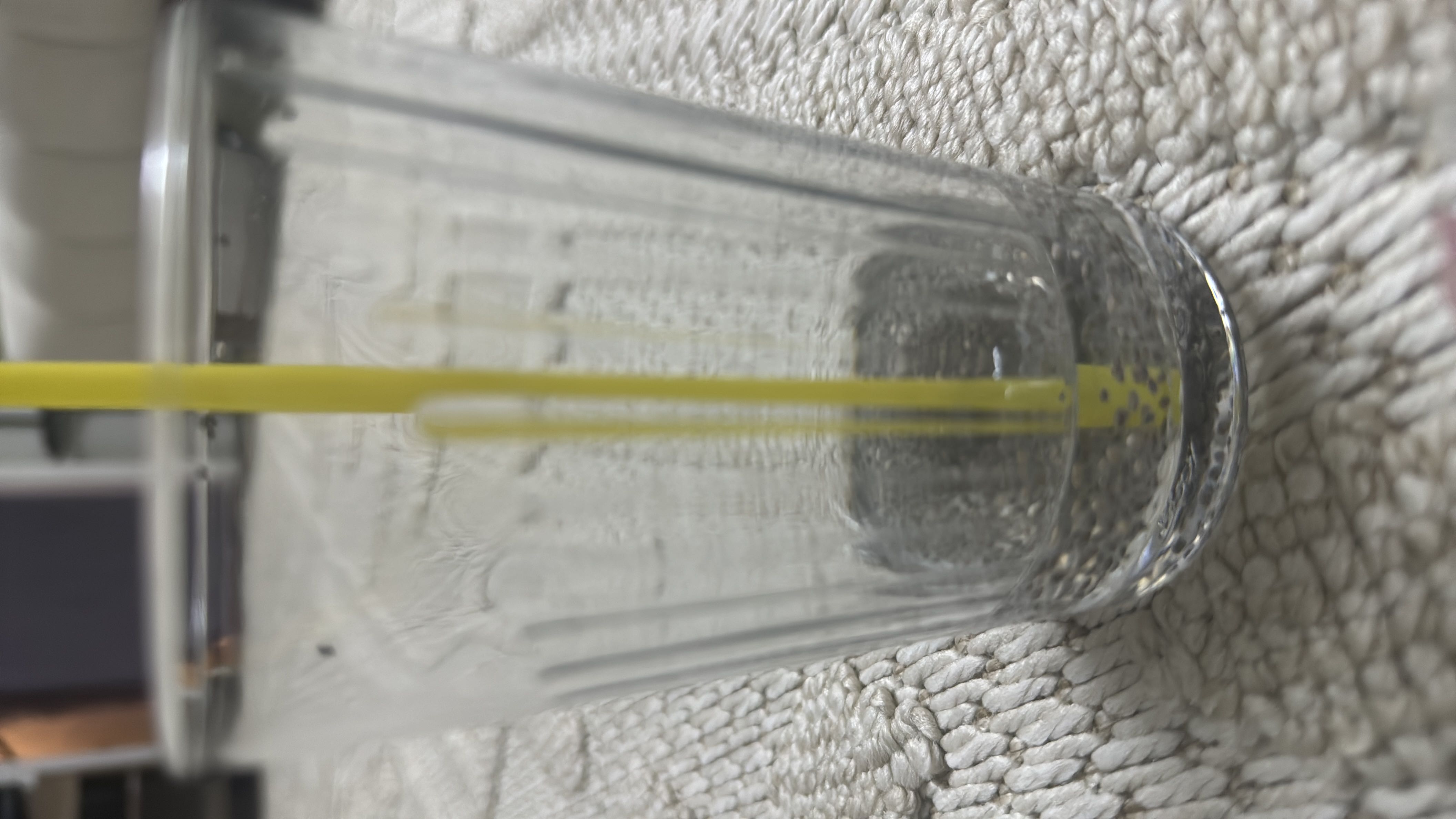 The image shows an empty glass with a straw, likely containing water, which has no significant nutritional content.