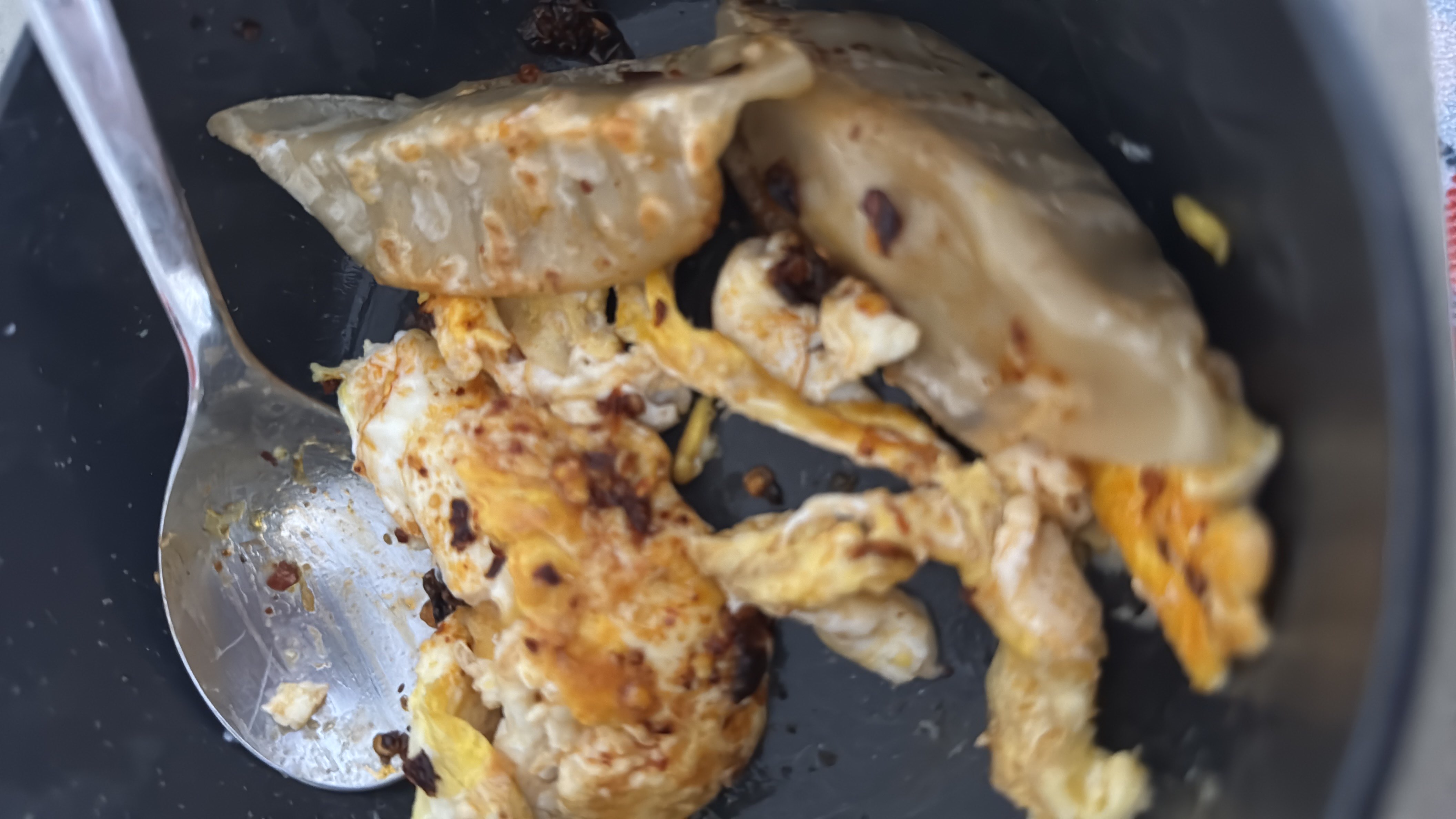 A dish consisting of pan-fried eggs, dumplings, and chili oil, providing a balanced mix of protein, carbs, and fats.