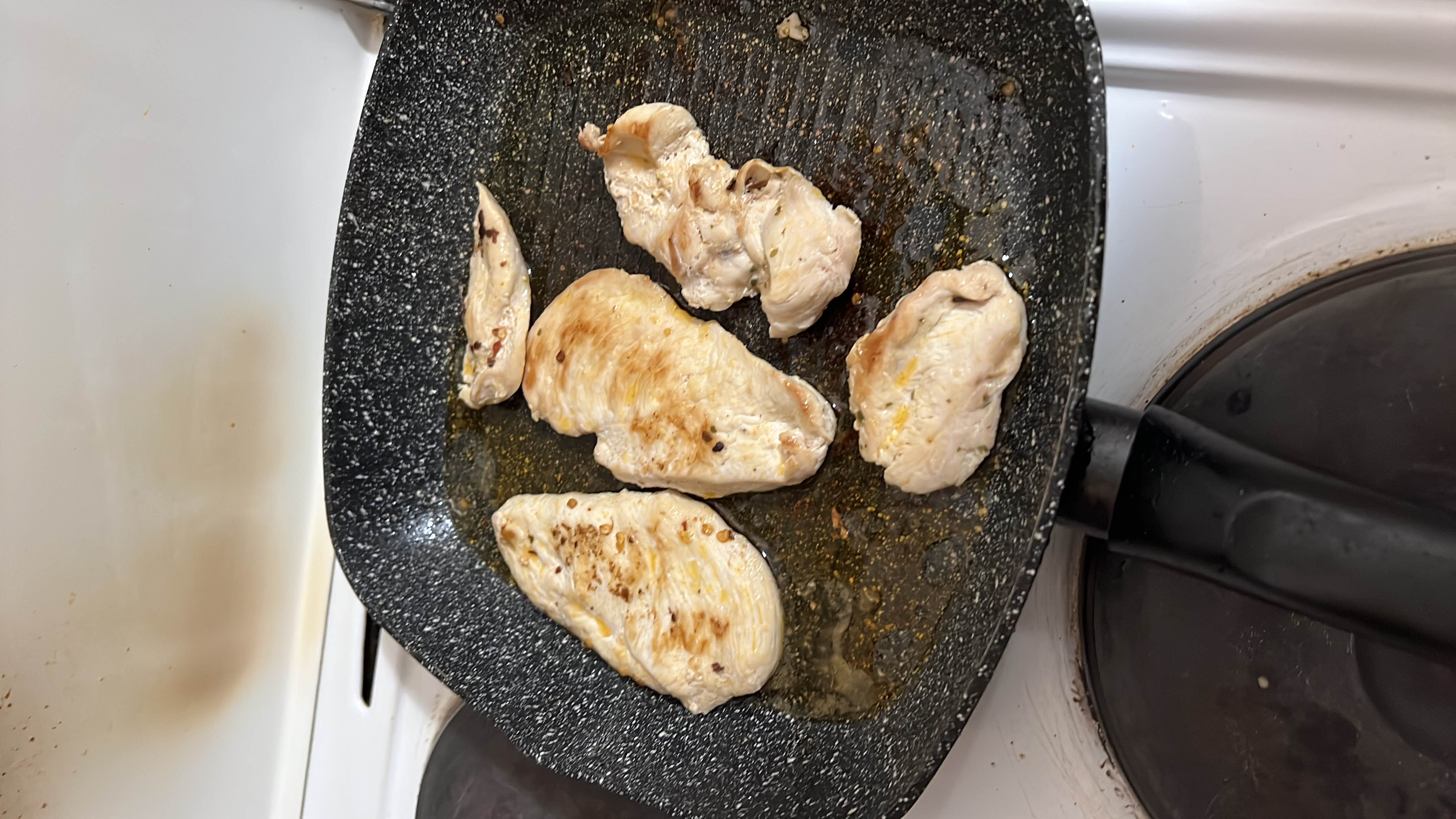Grilled chicken breast cooked in a pan with minimal oil, providing a high-protein, low-carb meal option.