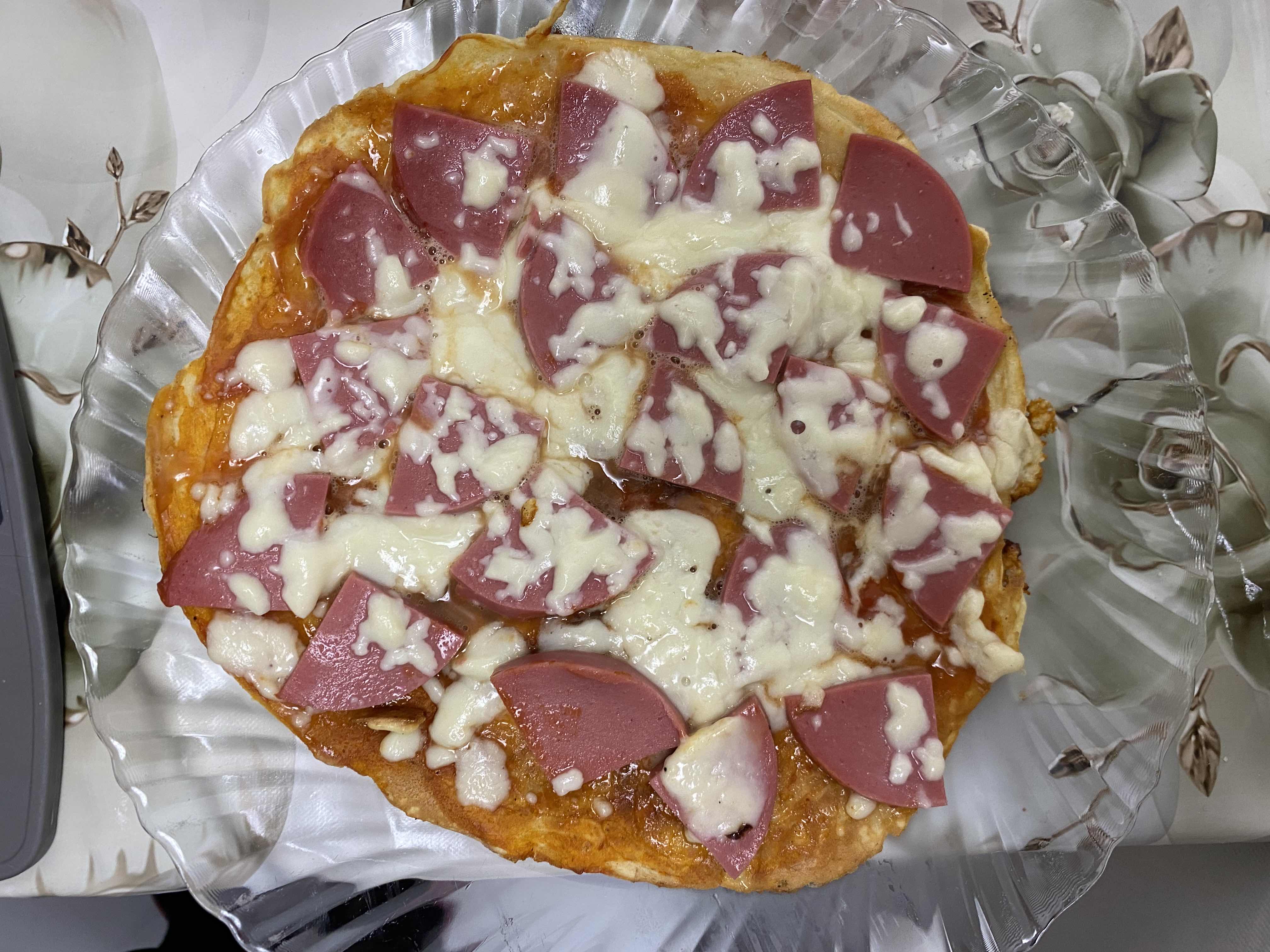 A homemade pizza topped with cheese and sausage slices, providing a balanced mix of protein, carbs, and fats.