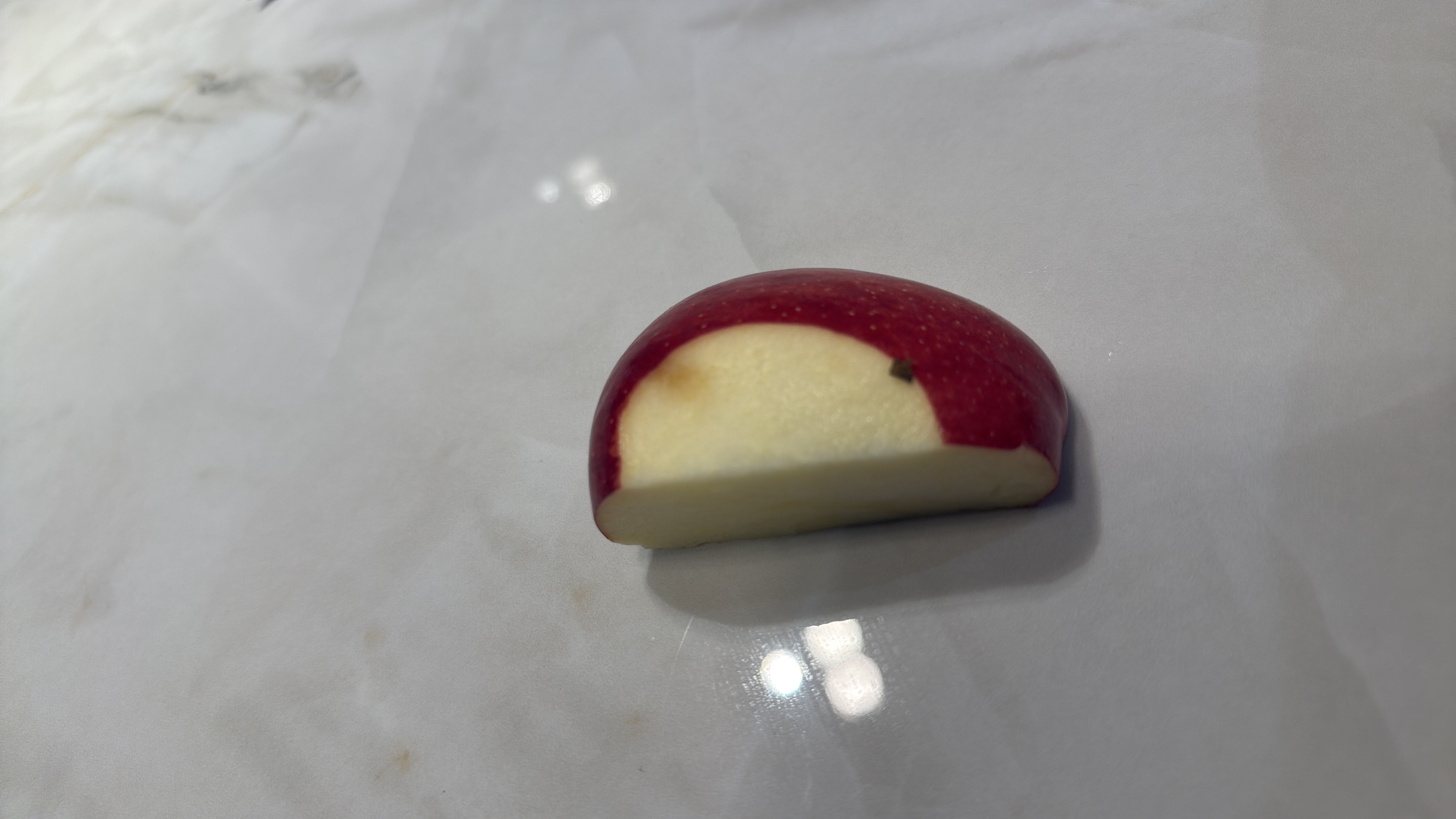 A single slice of apple, low in calories and rich in carbohydrates, suitable for a healthy snack.